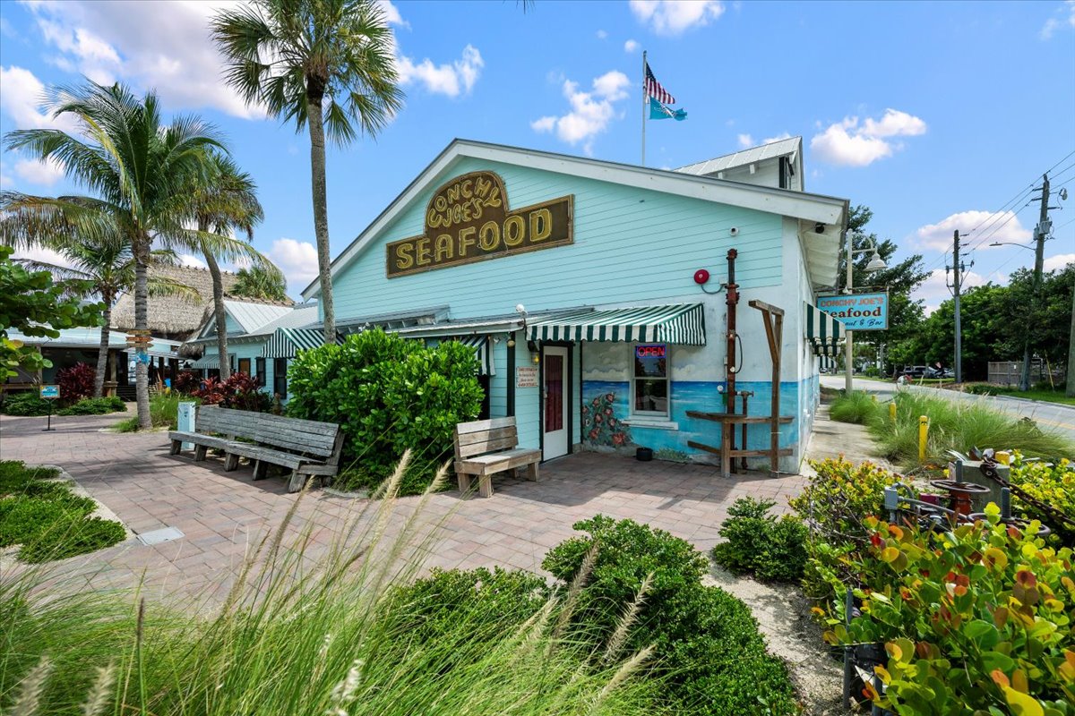 Charming tropical seafood spot with palm trees and coastal curb appeal