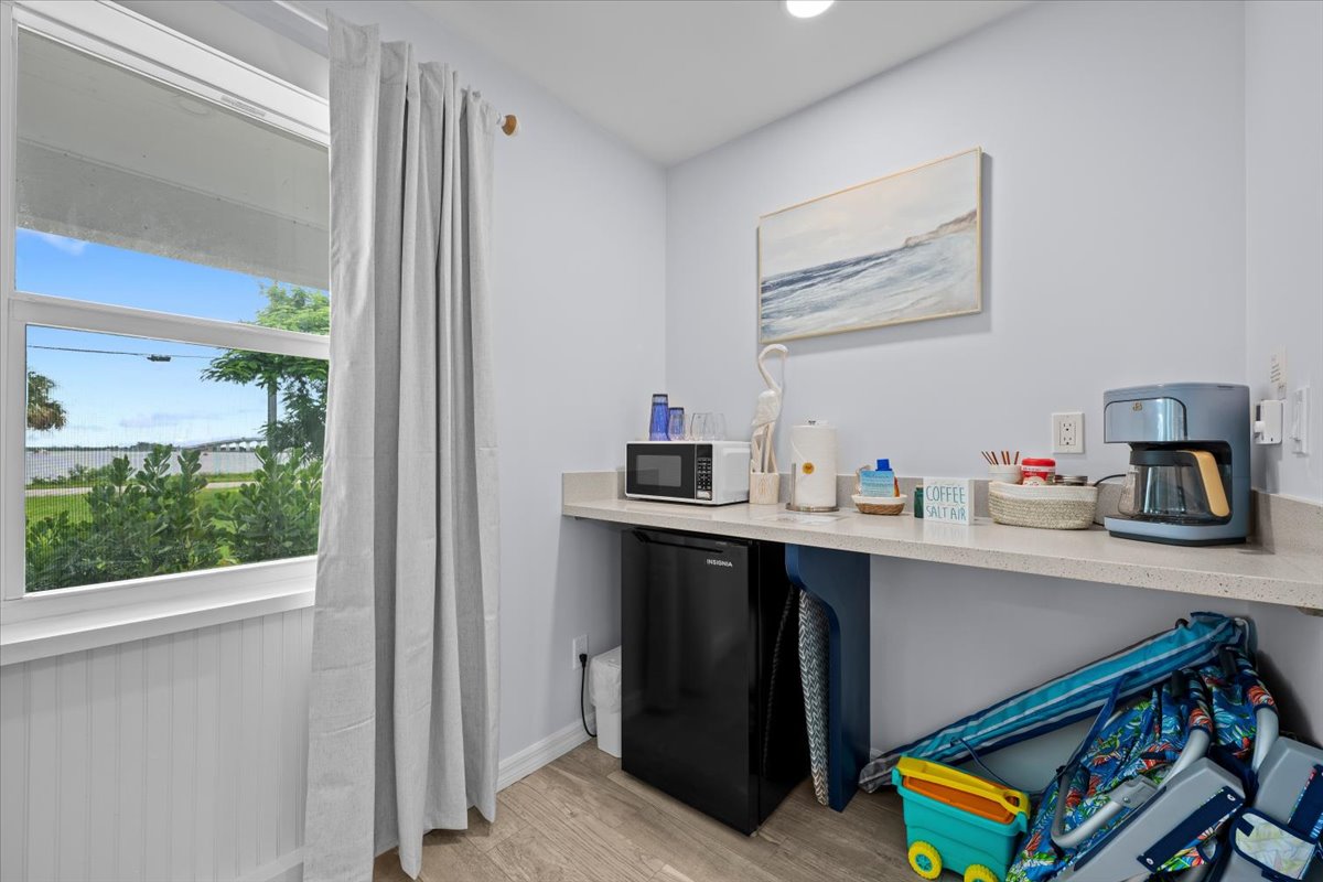 Bright coffee station with mini fridge, microwave, and handy beach gear