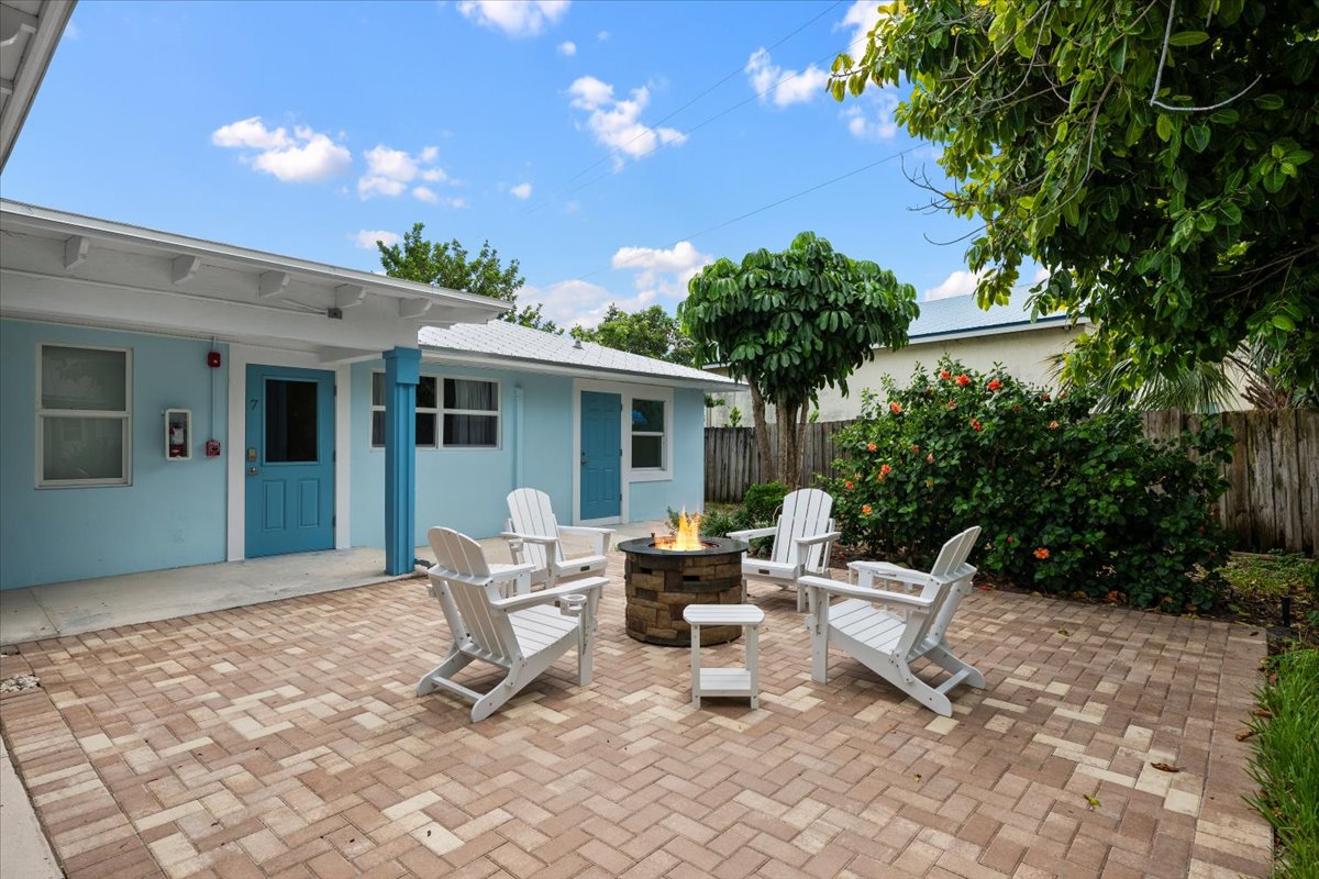 Private tropical patio with fire pit and Adirondack seating