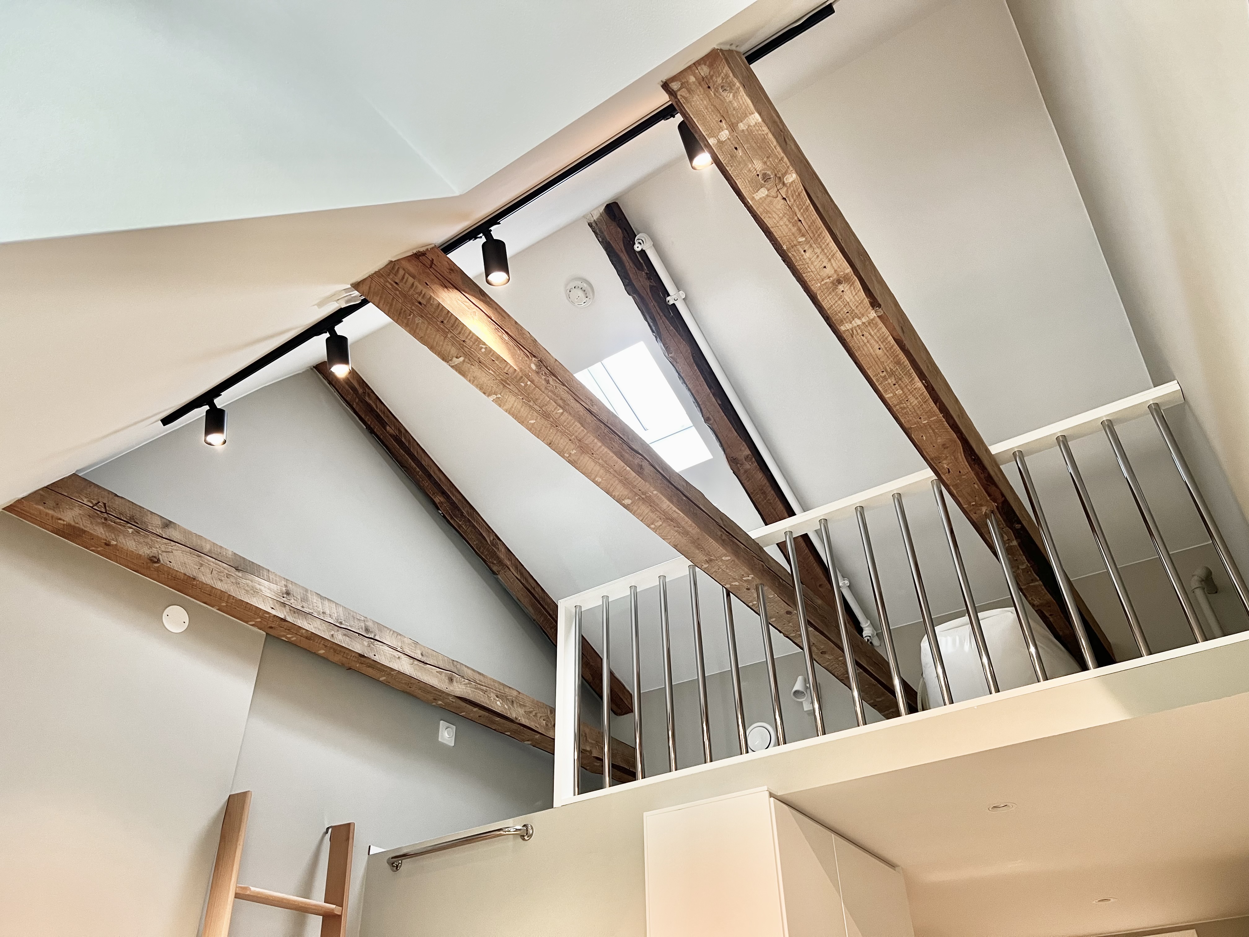 Bright loft with exposed beams, skylight, and airy vaulted ceilings
