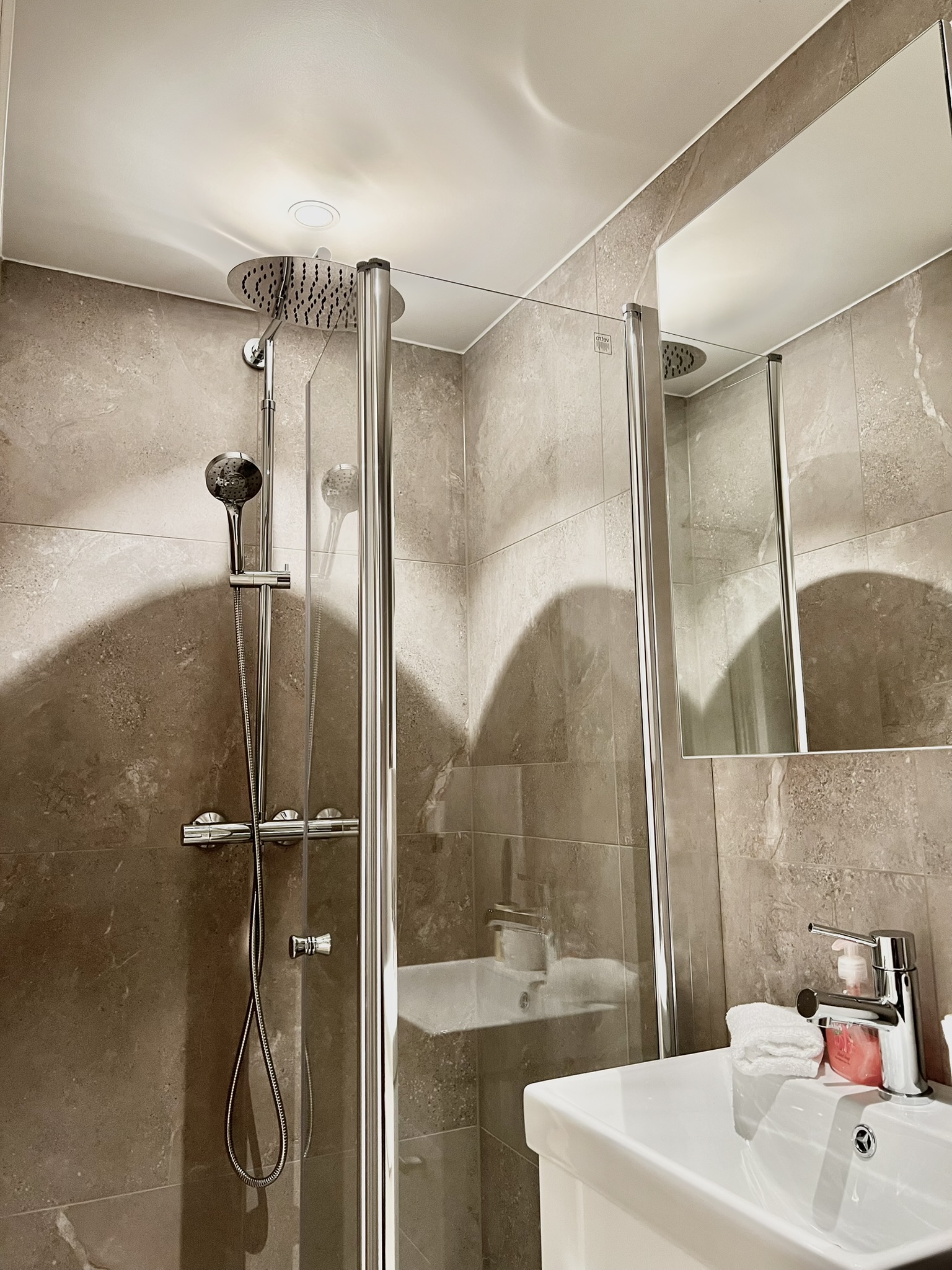Private Modern spa-style bathroom with rainfall shower and sleek finishes