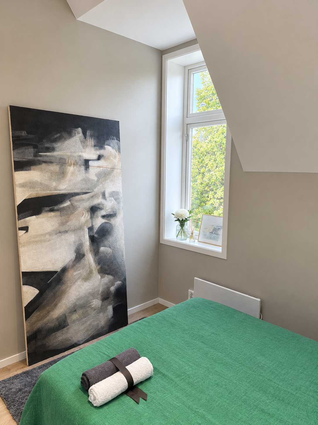 Bright, cosy bedroom with modern artwork and a lovely view overlooking St. Hanshaugen Park.