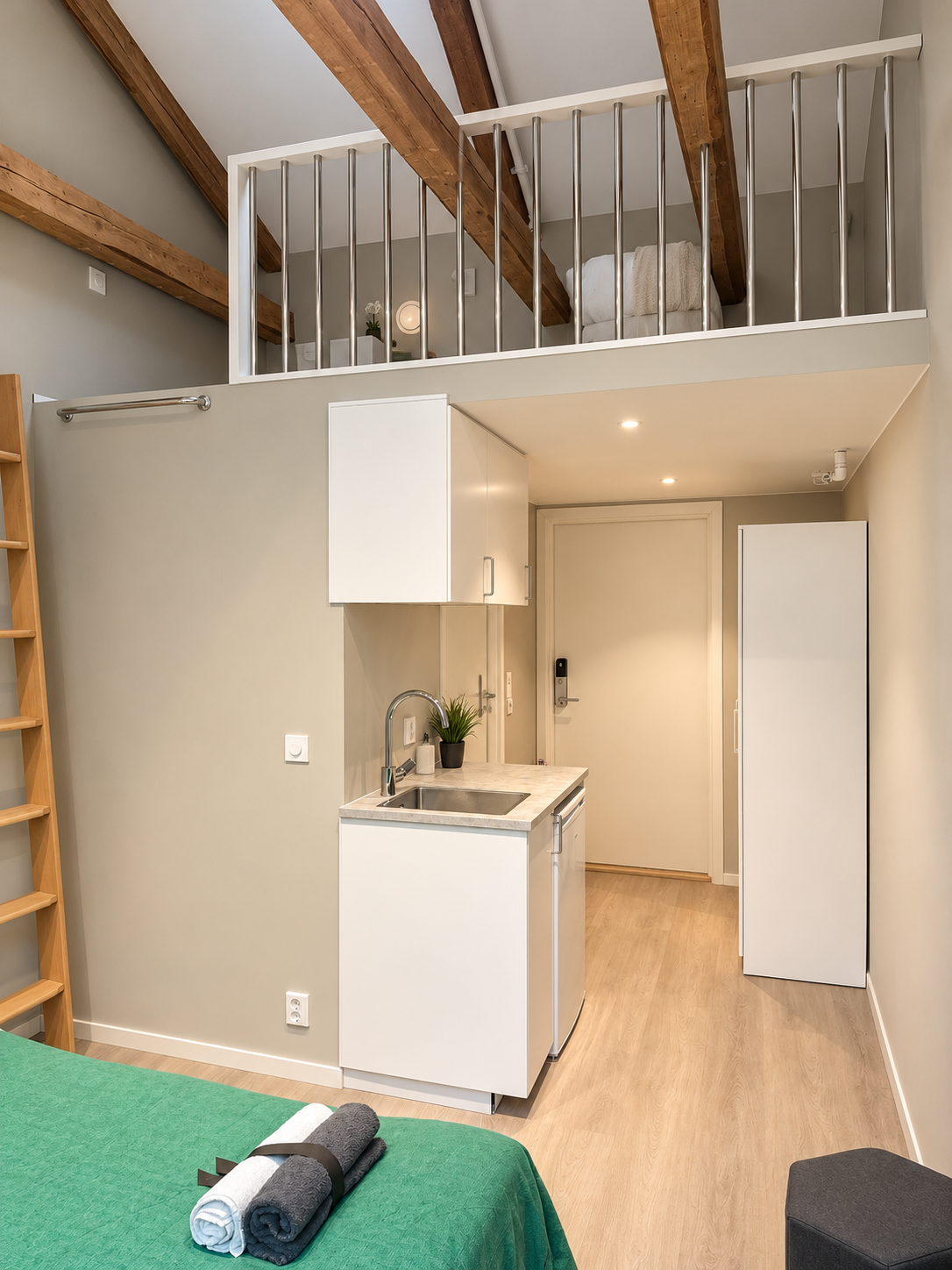 Cozy loft studio with kitchenette, exposed beams, and modern Scandinavian style