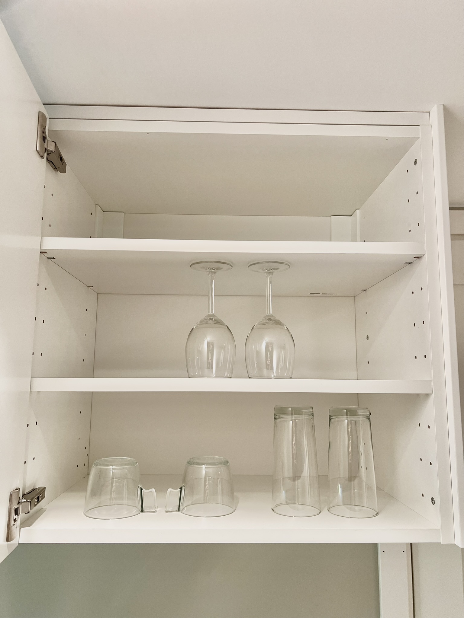 Organized kitchen cabinet with wine glasses and everyday drinkware