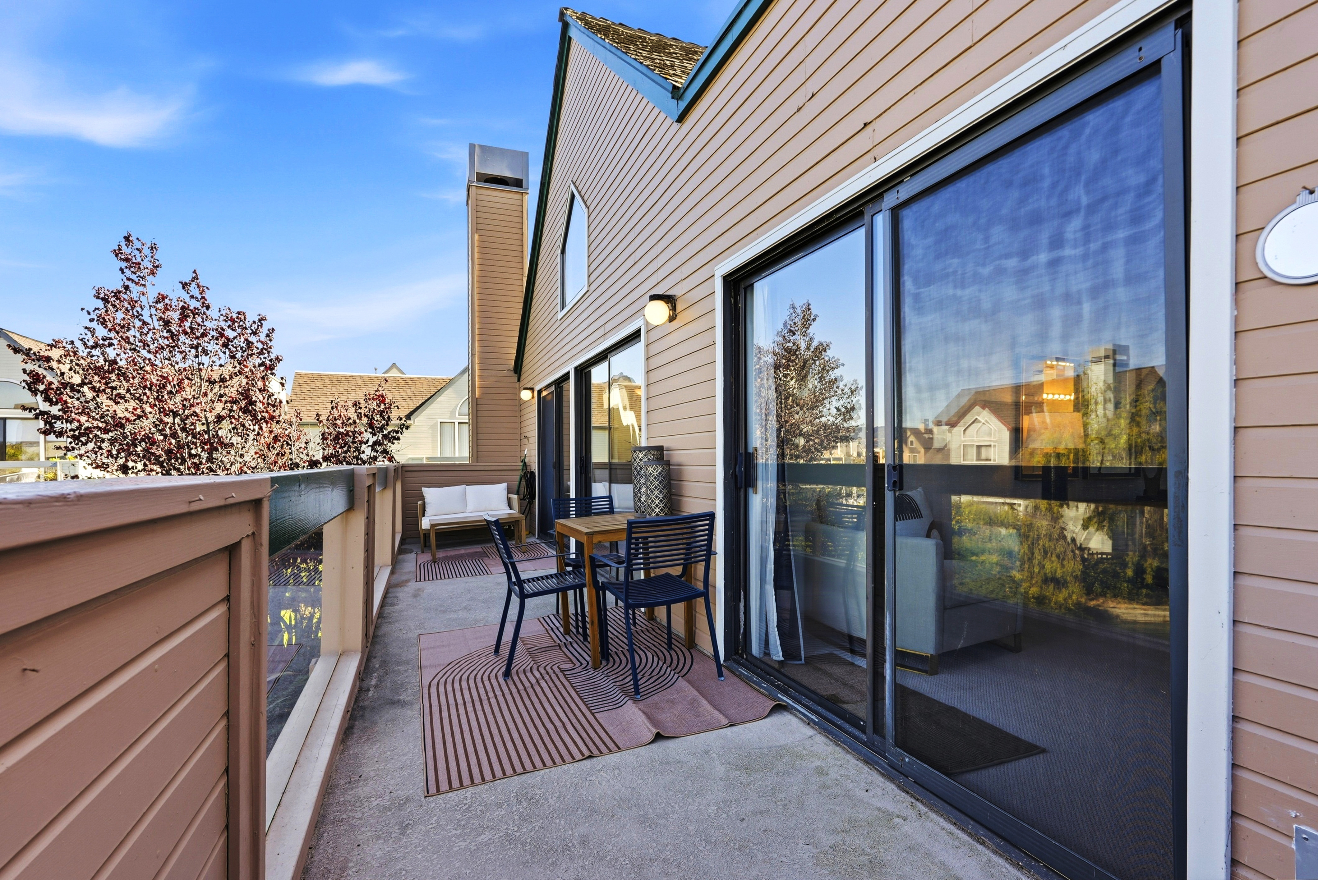 Private balcony with outdoor seating and bright sliding door access