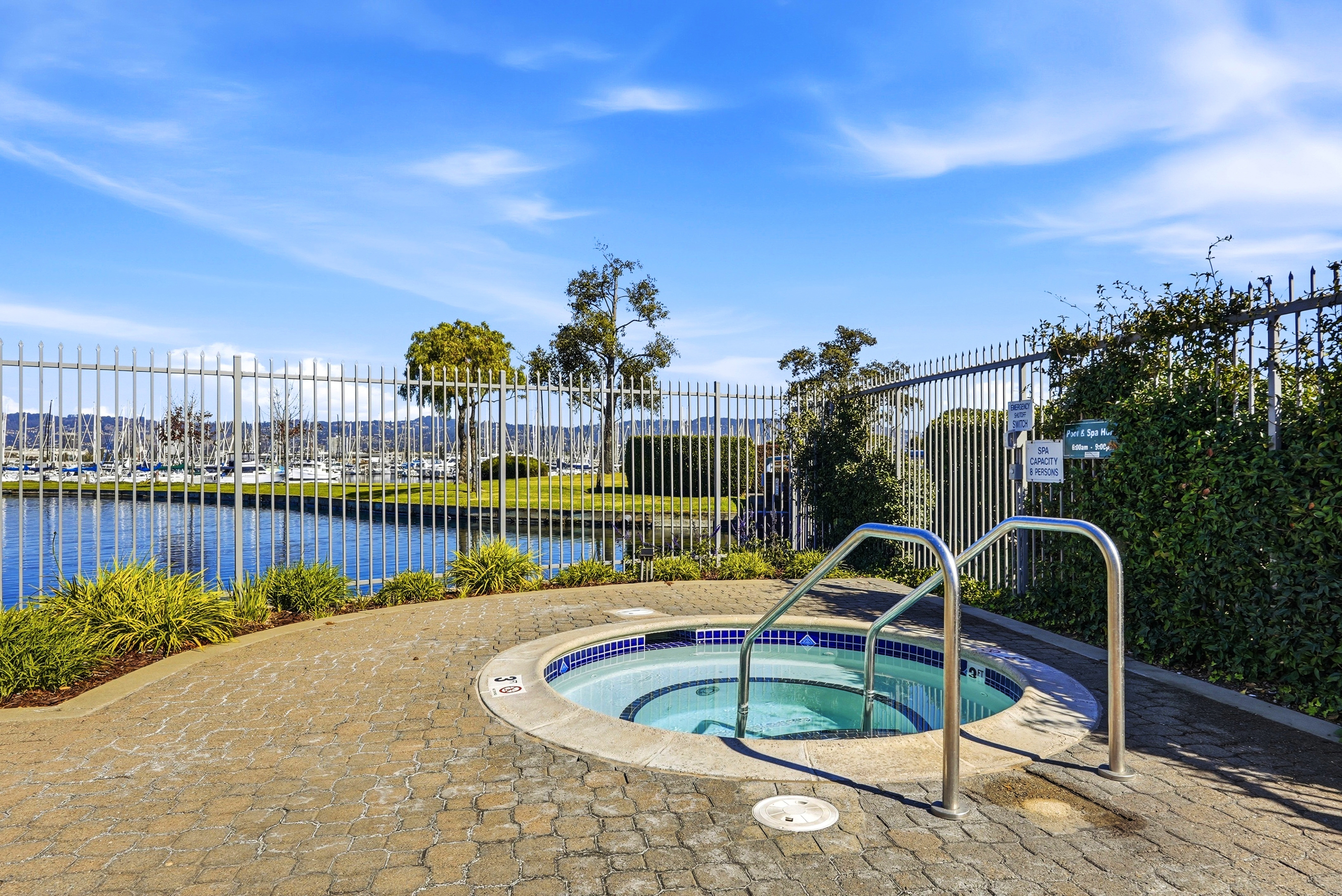 Relax in the outdoor spa with peaceful waterfront and marina views
