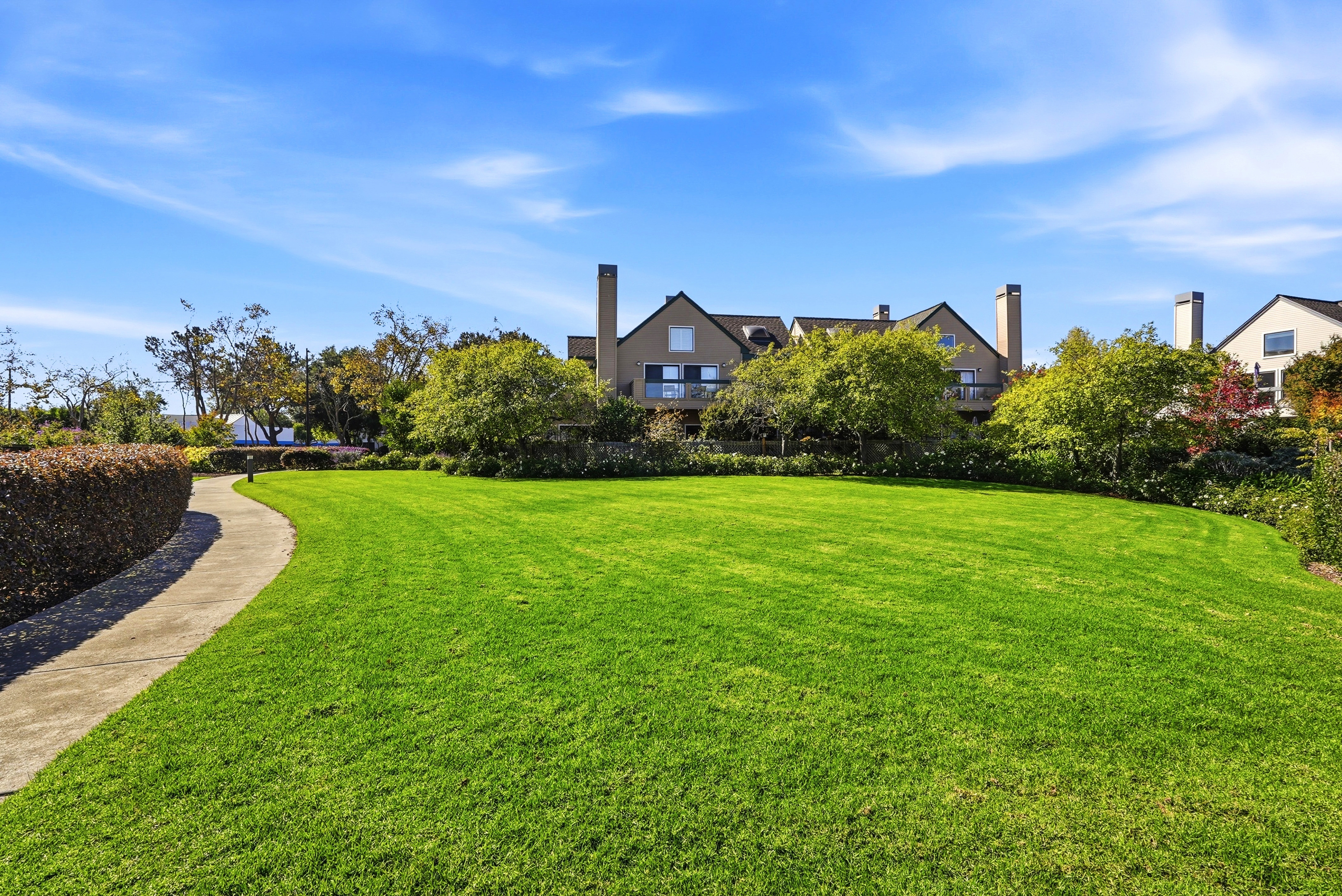 Spacious manicured lawn with scenic walking path and peaceful surroundings