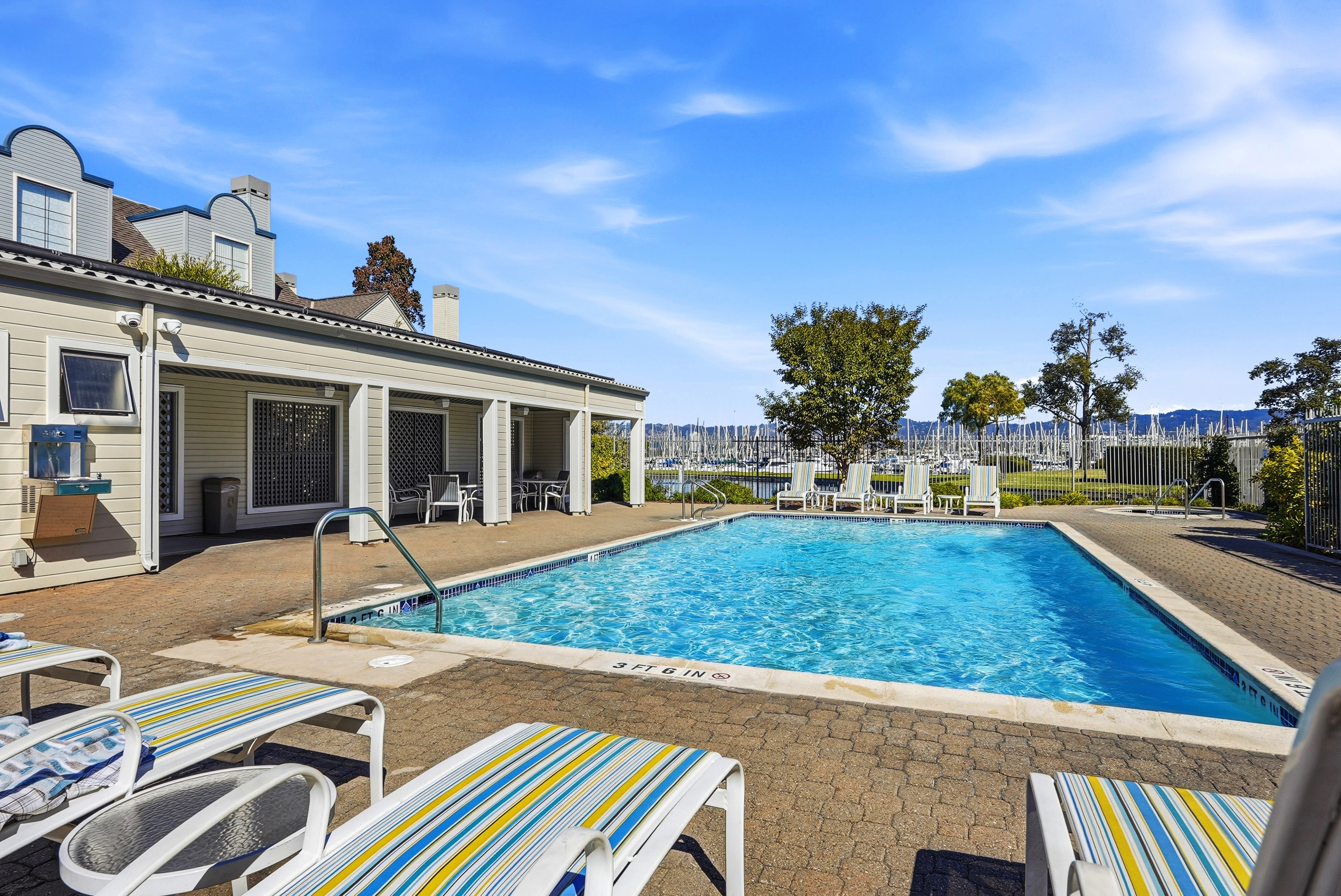 Sunny pool deck with lounge chairs and relaxing marina views