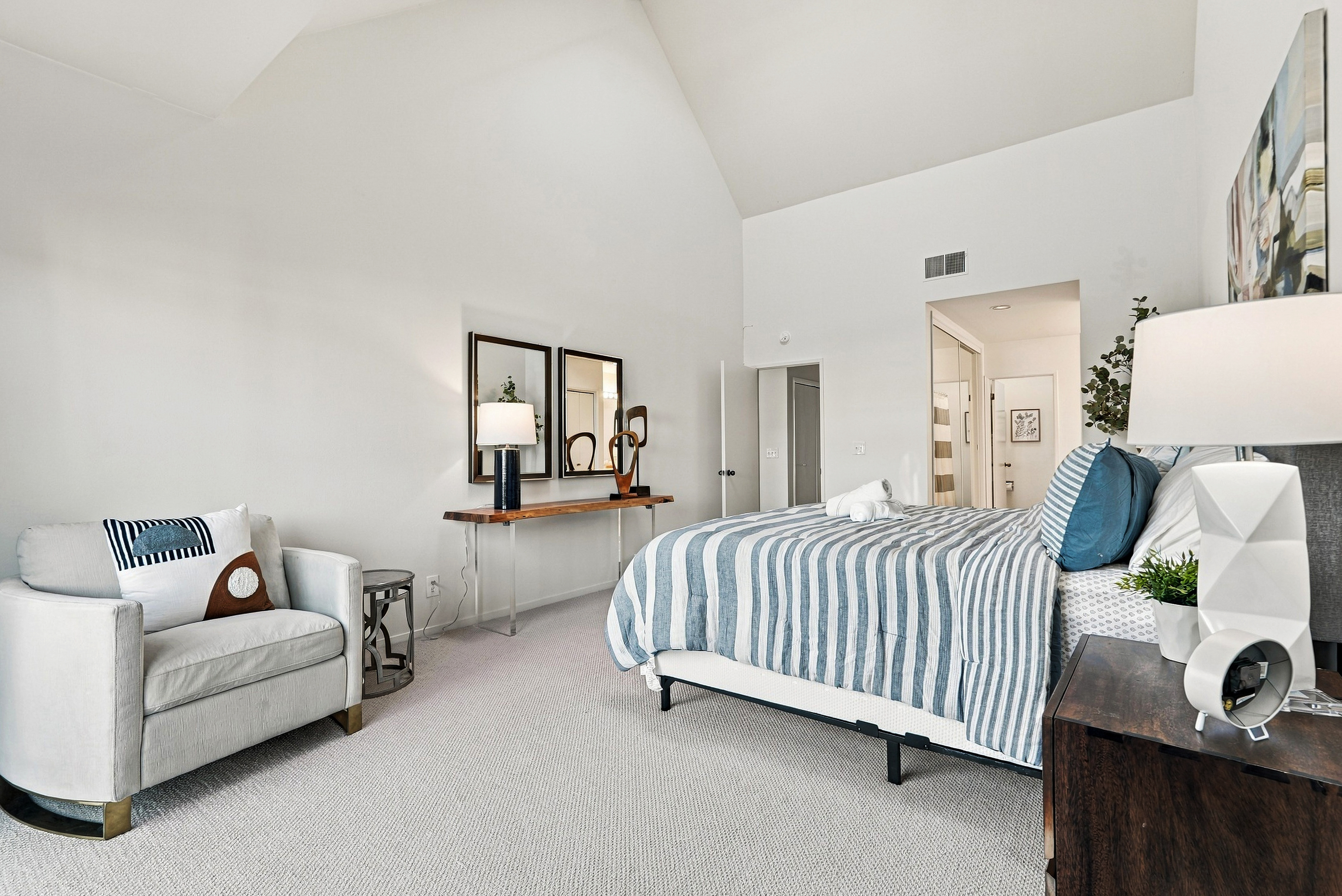 Bright vaulted bedroom with cozy seating and airy modern style