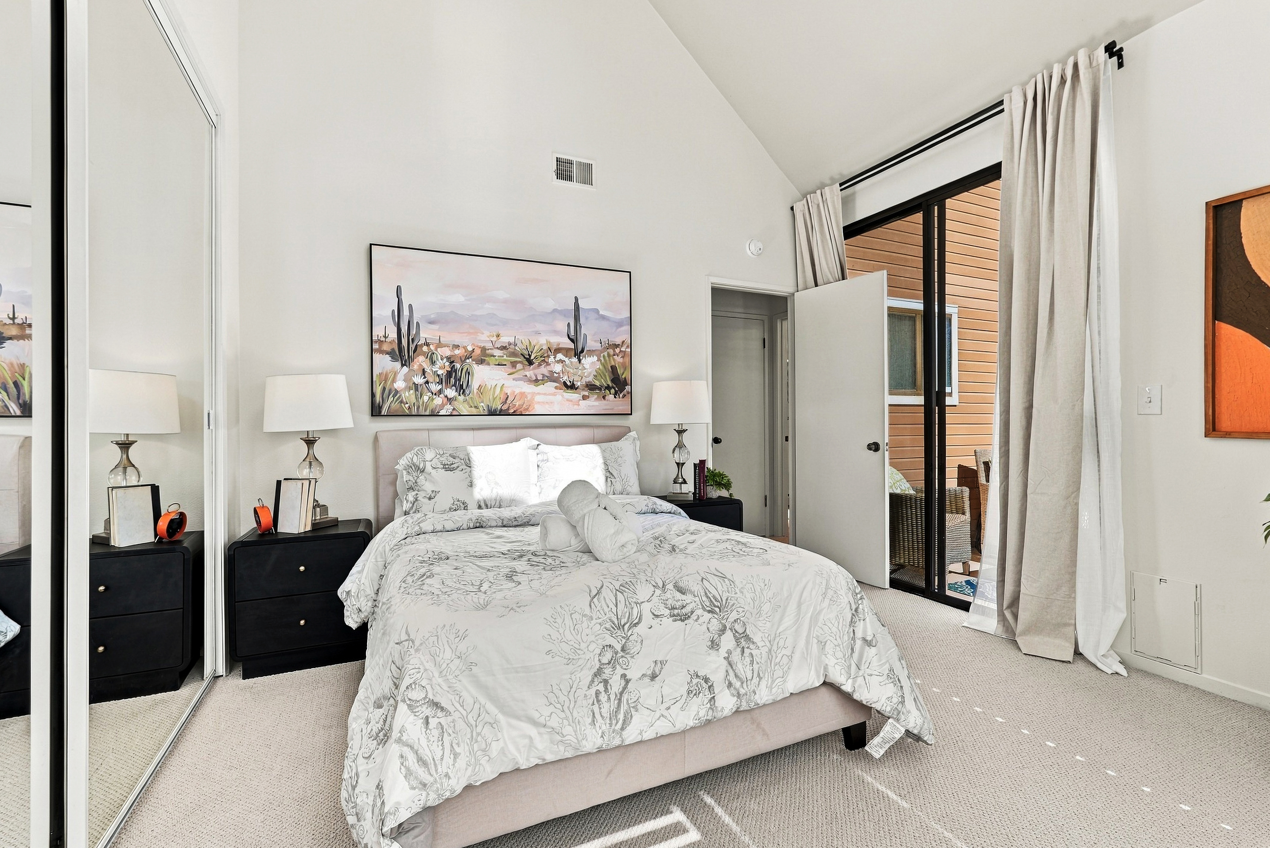 Bright vaulted bedroom with patio access and serene, airy design