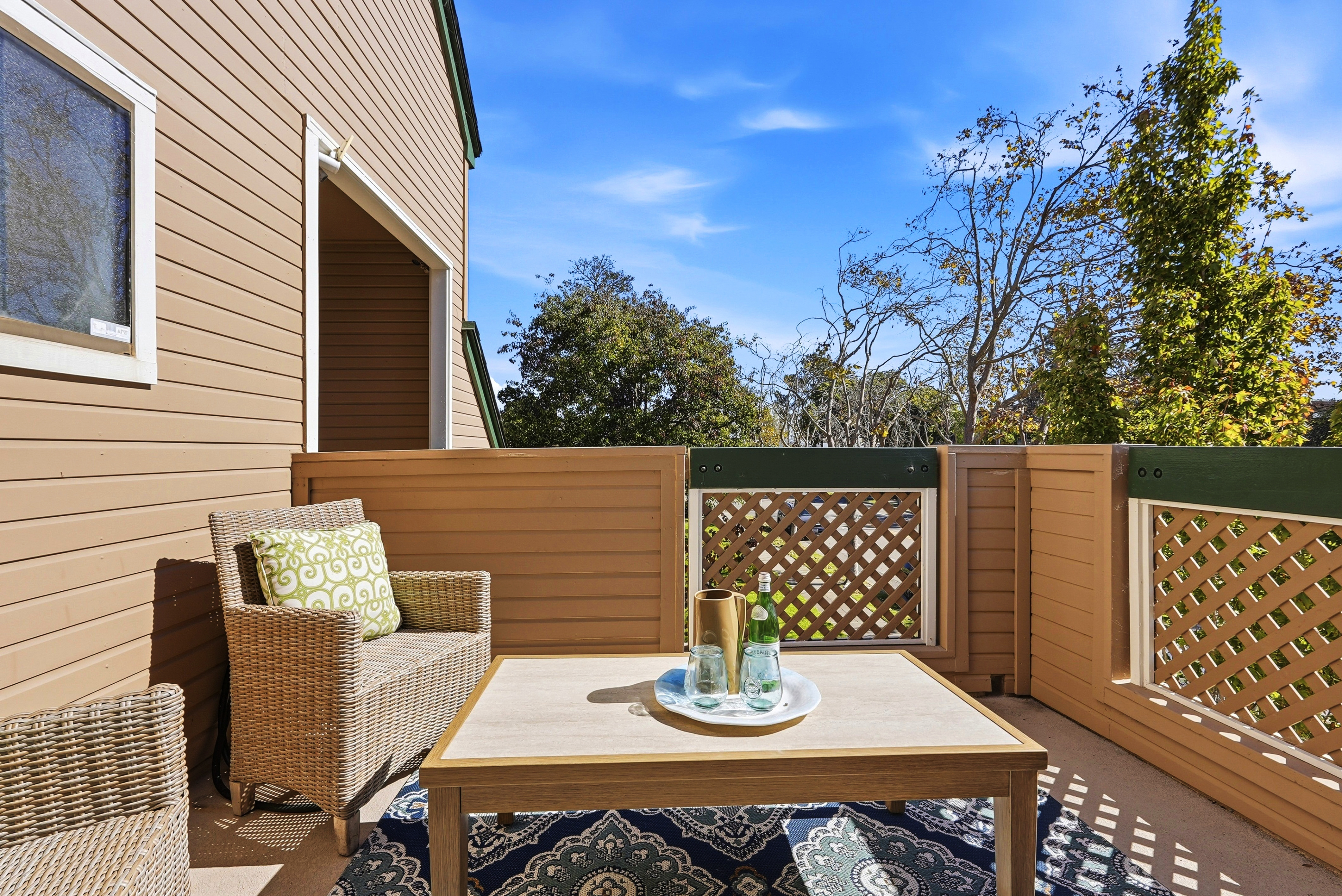 Sunny private balcony with cozy seating and relaxing outdoor lounge space