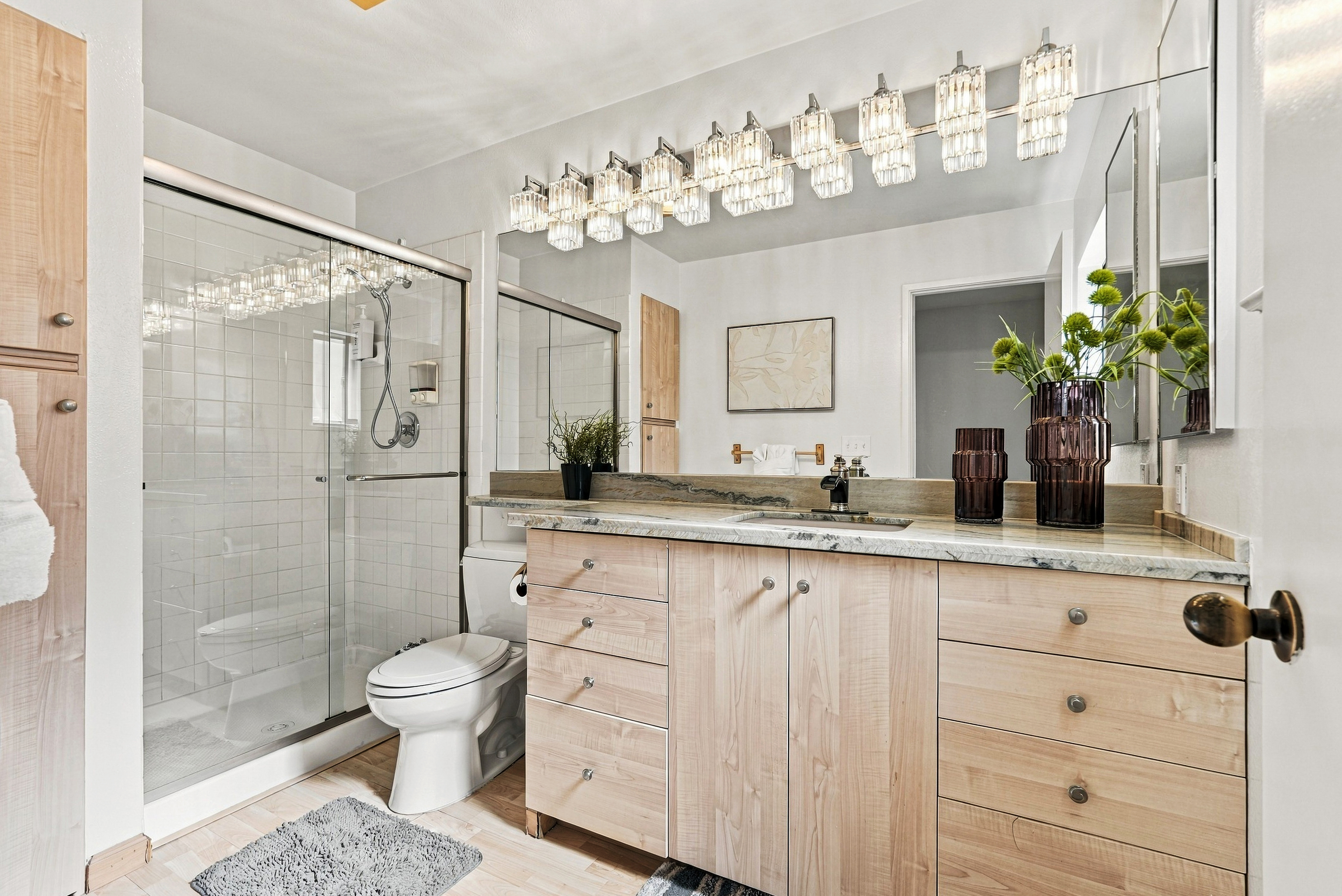 Bright spa-style bathroom with double vanity and glass walk-in shower