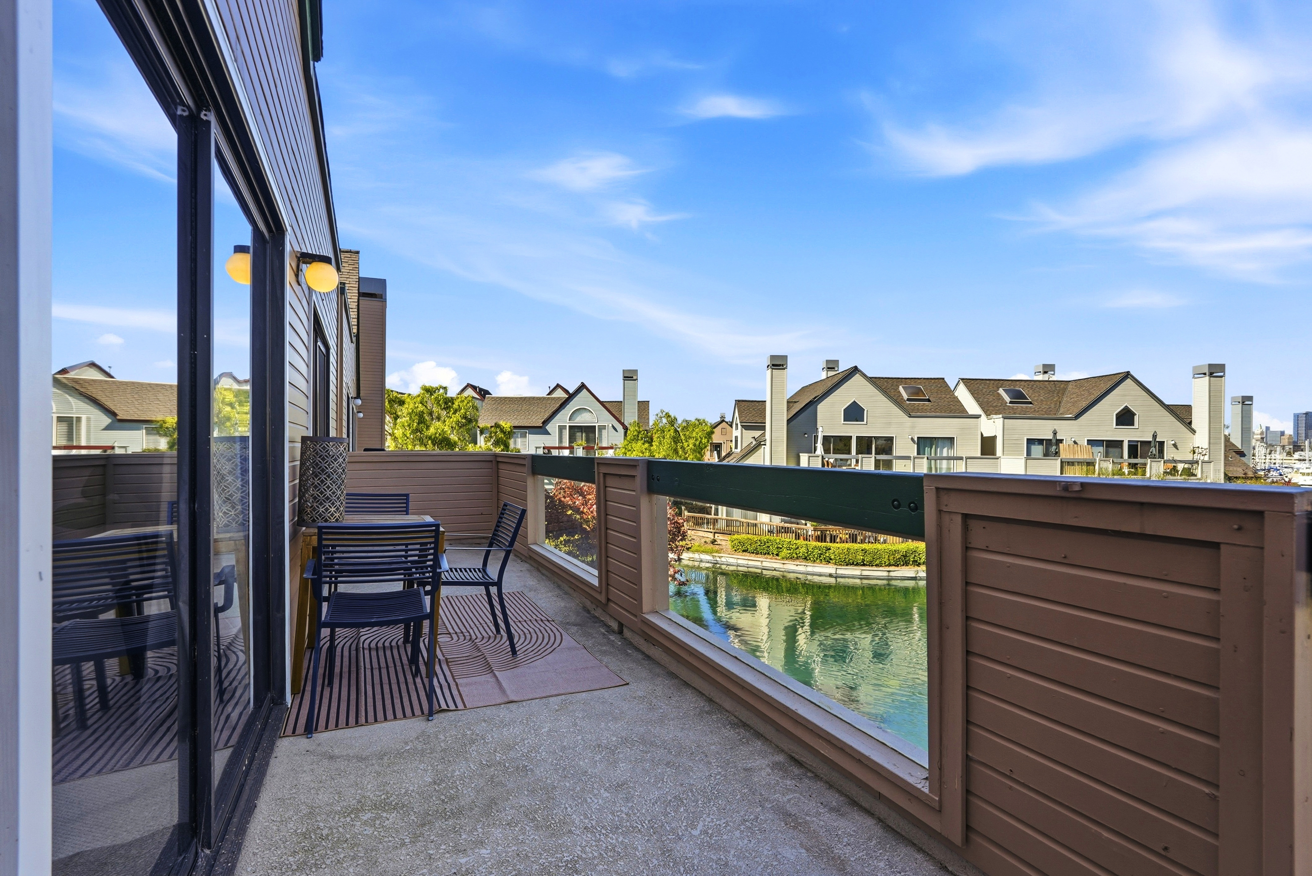 Private waterfront balcony with seating and serene canal views