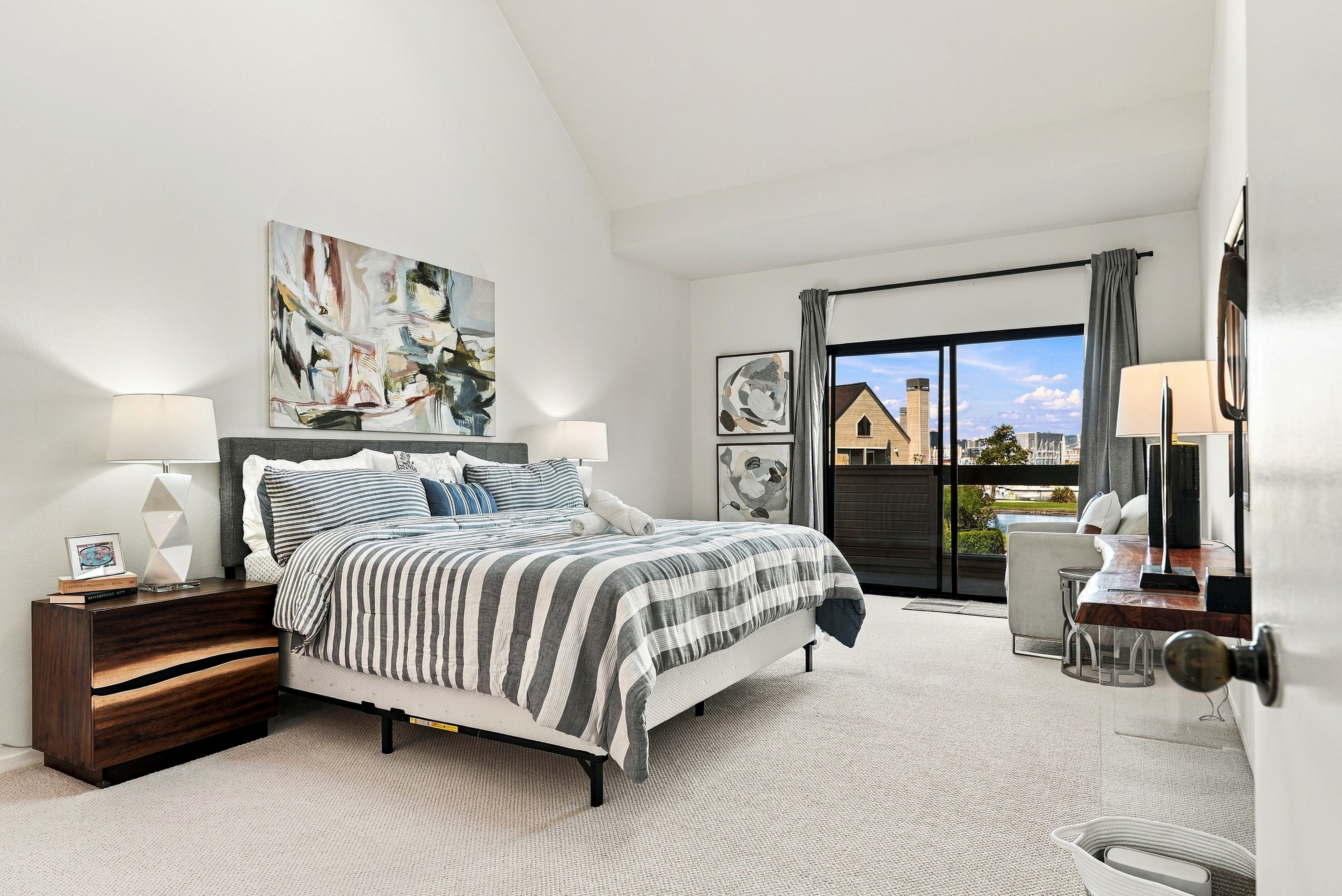 Bright, spacious bedroom with vaulted ceilings and private balcony views