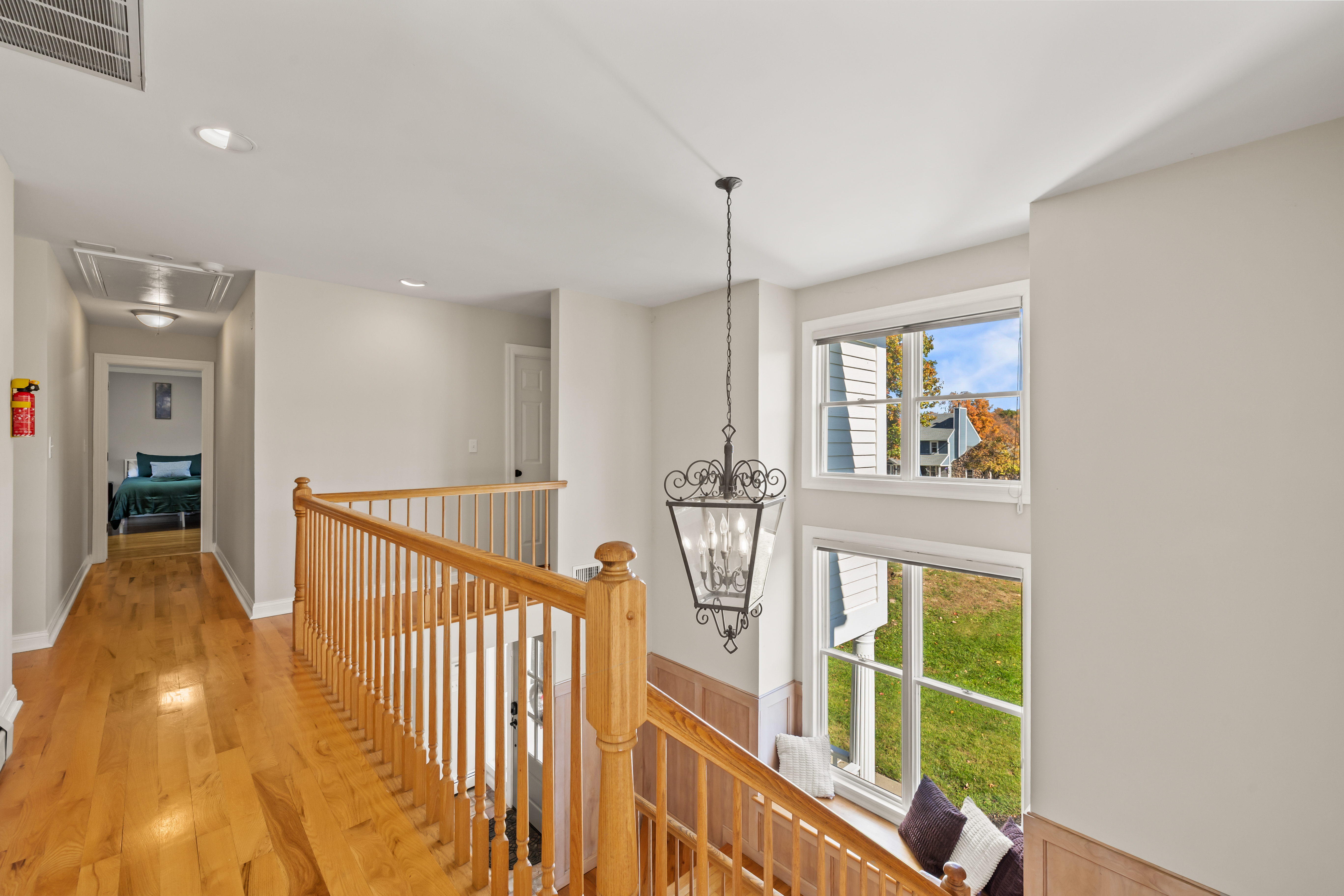 Bright upper landing with hardwood floors and sun-filled windows