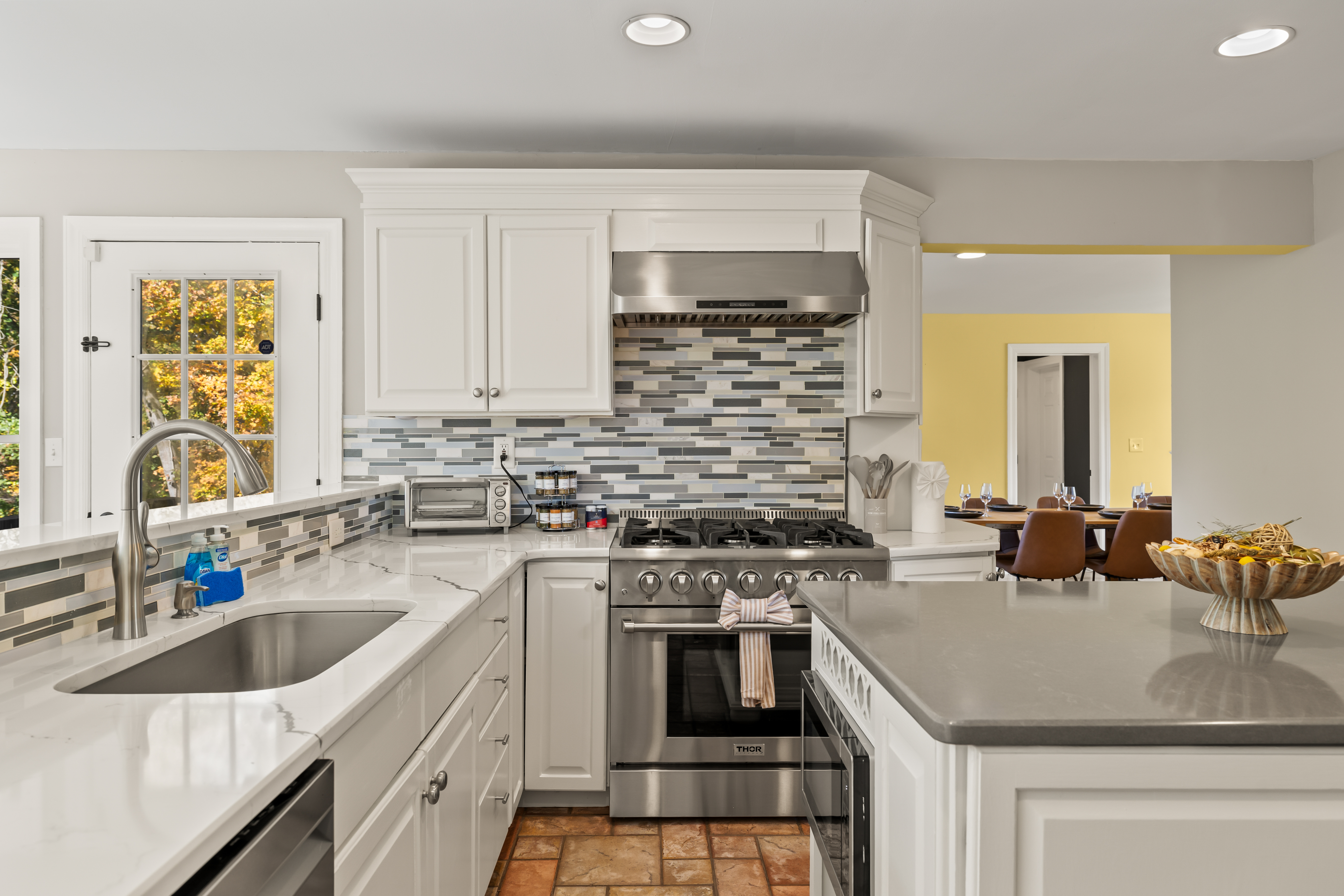 Bright modern kitchen with island, gas range, and open dining flow