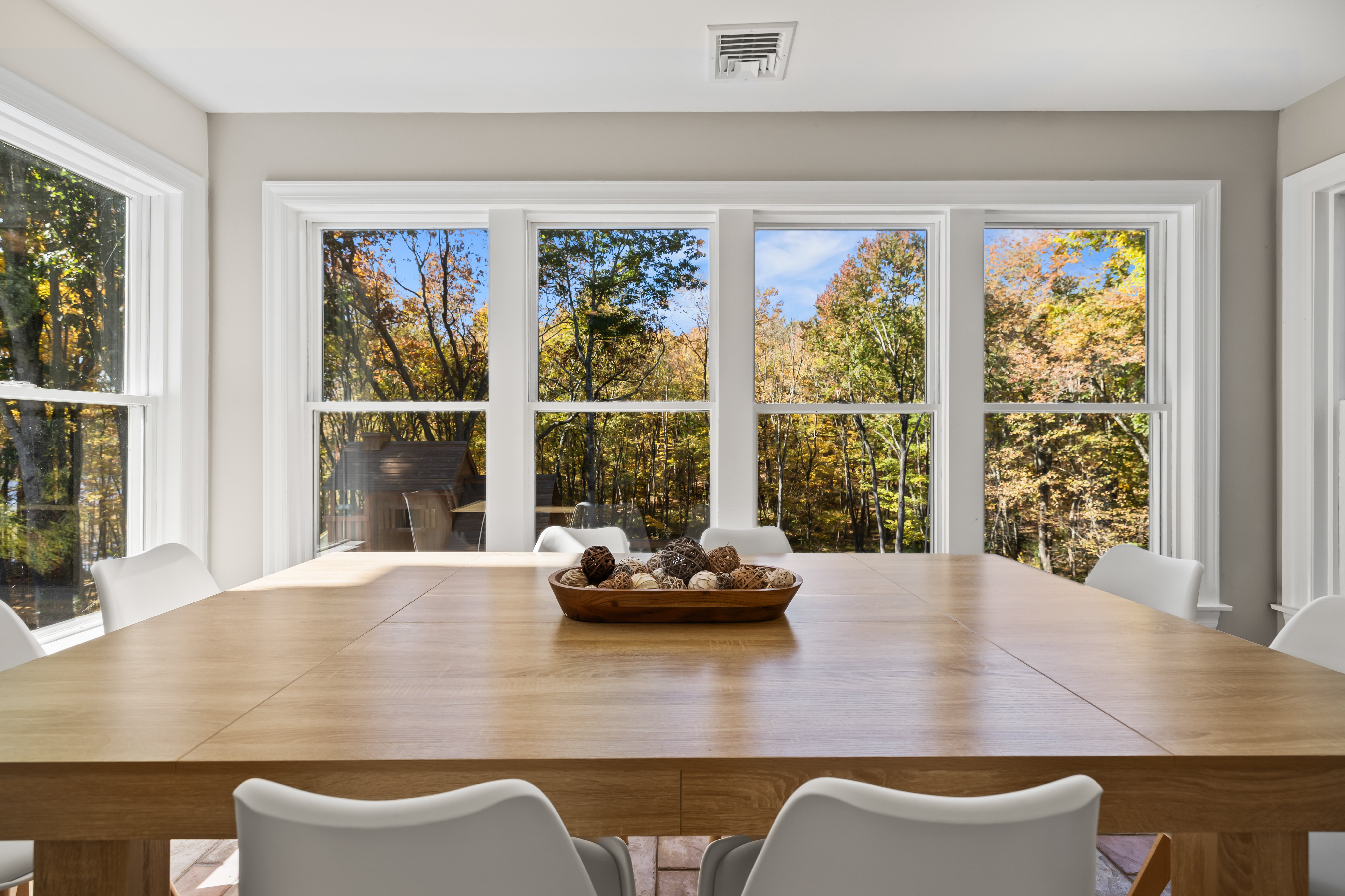 Bright dining room with large windows and peaceful forest views