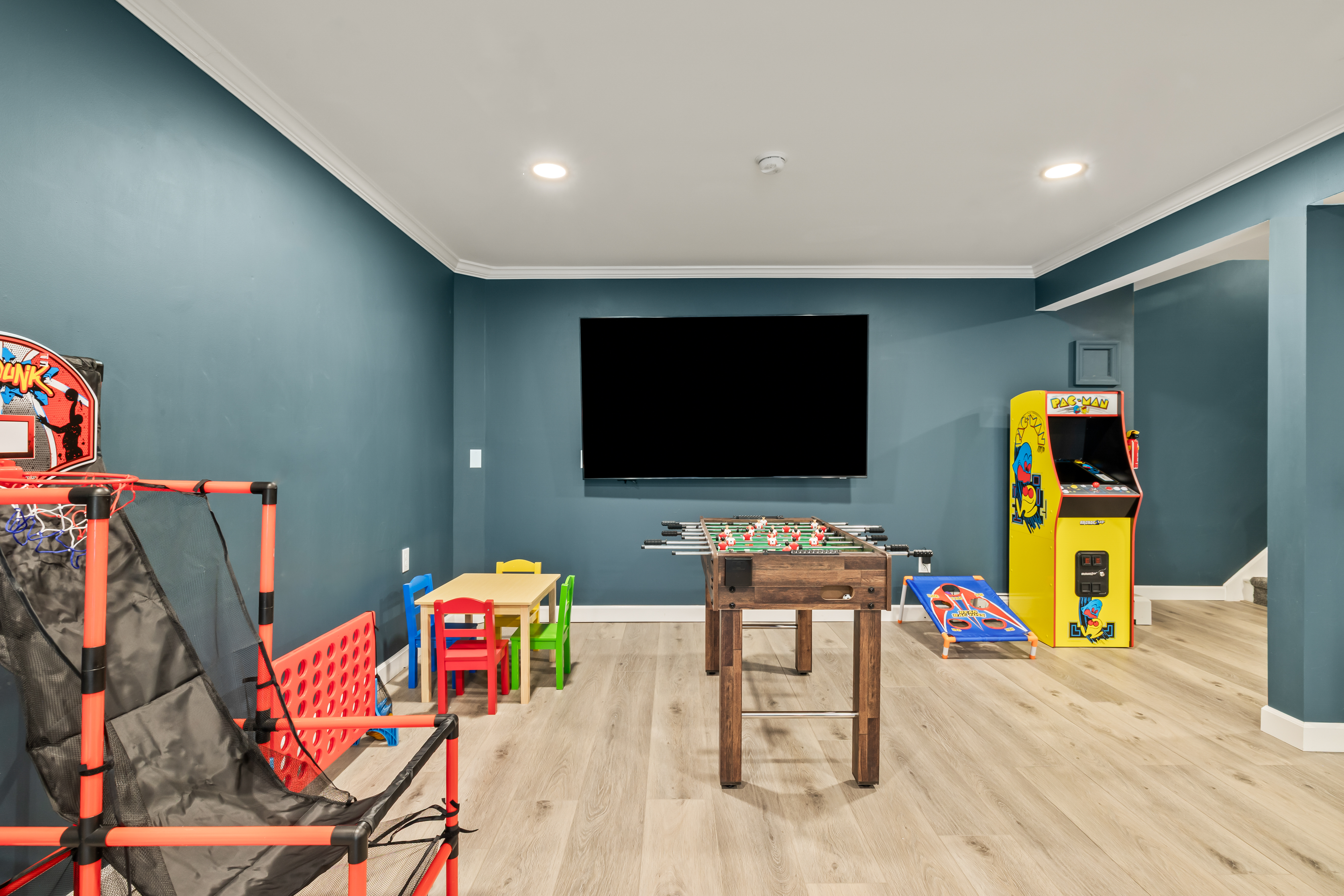 Family-friendly game room with arcade, foosball, TV, and kids’ play area