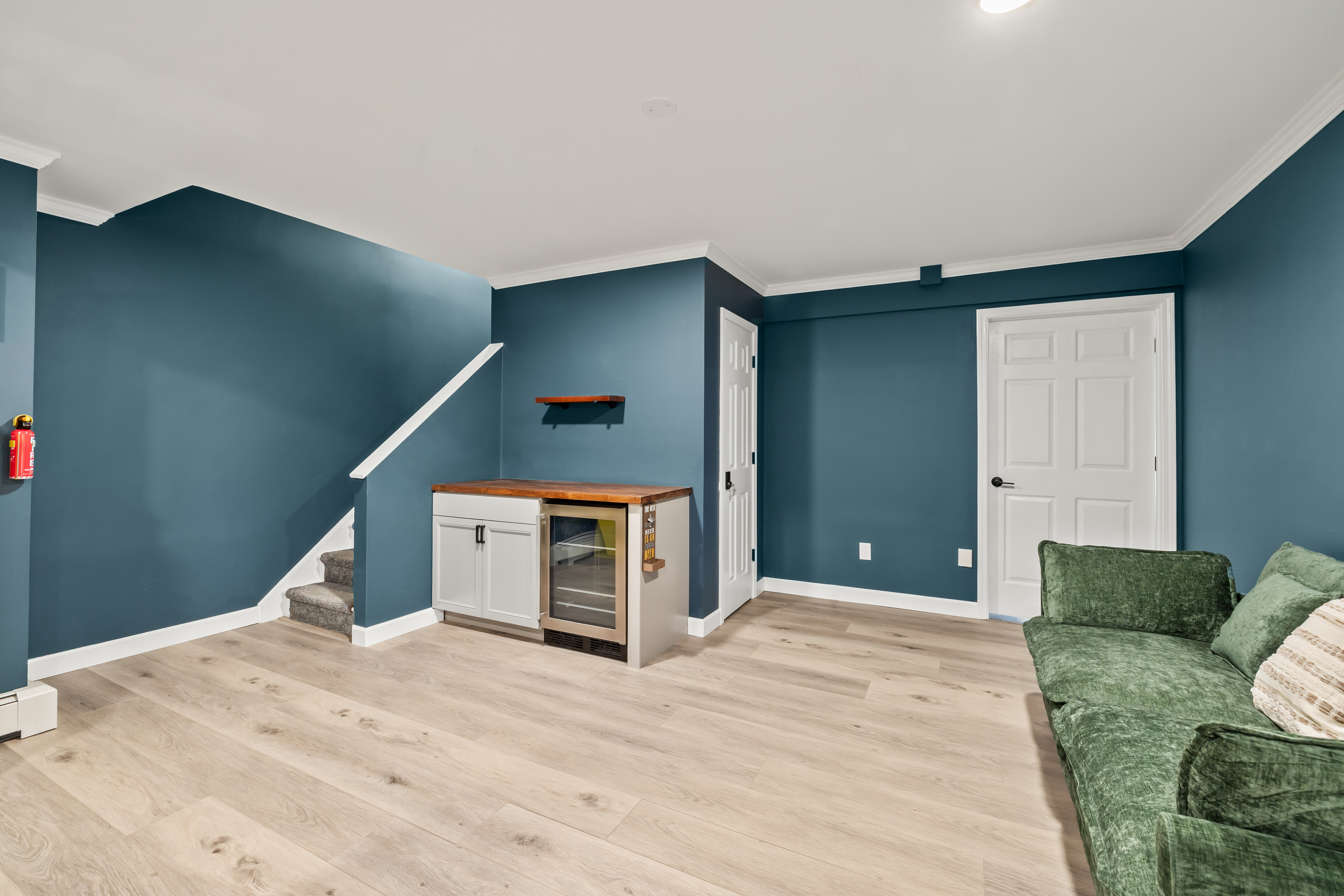 Stylish bonus lounge with wet bar, beverage fridge, and cozy seating
