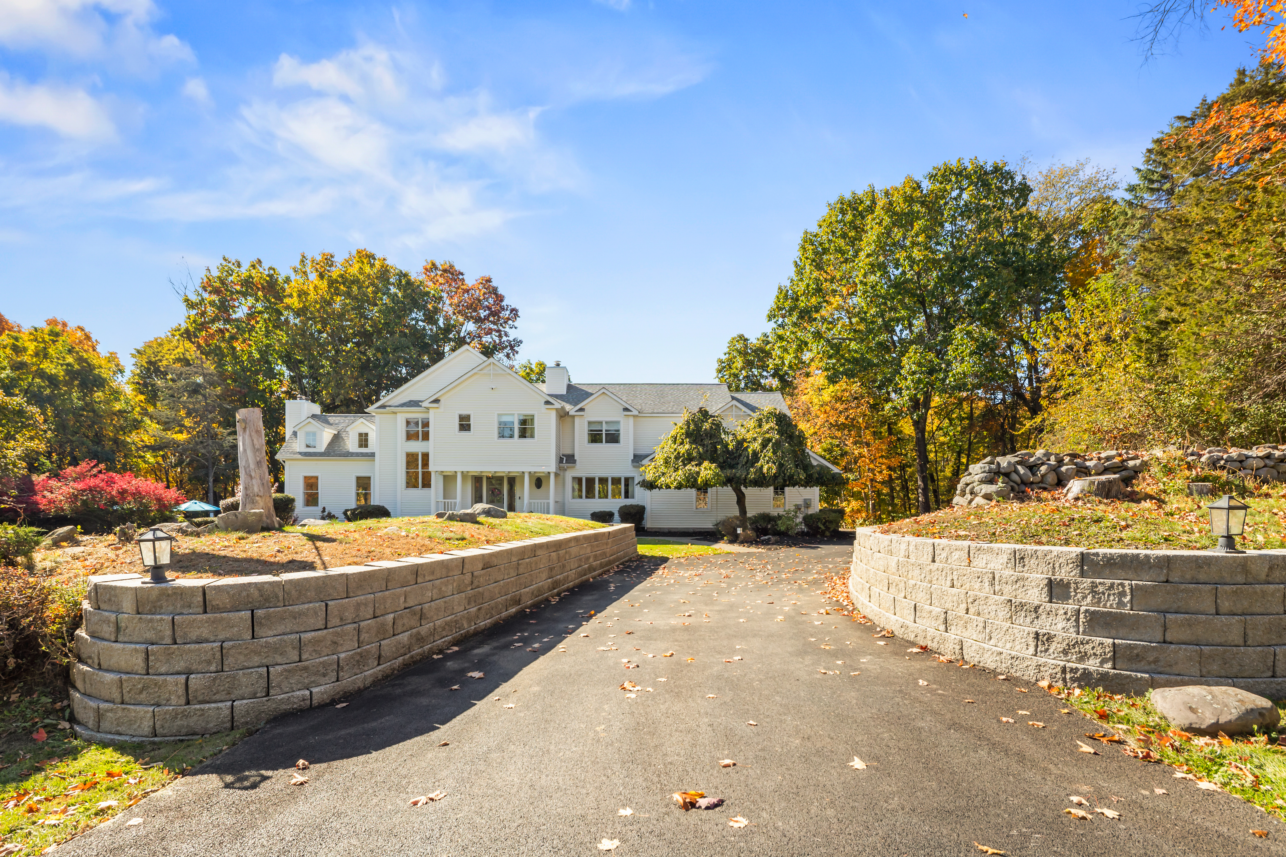 Private tree-lined drive with stunning fall views and grand curb appeal