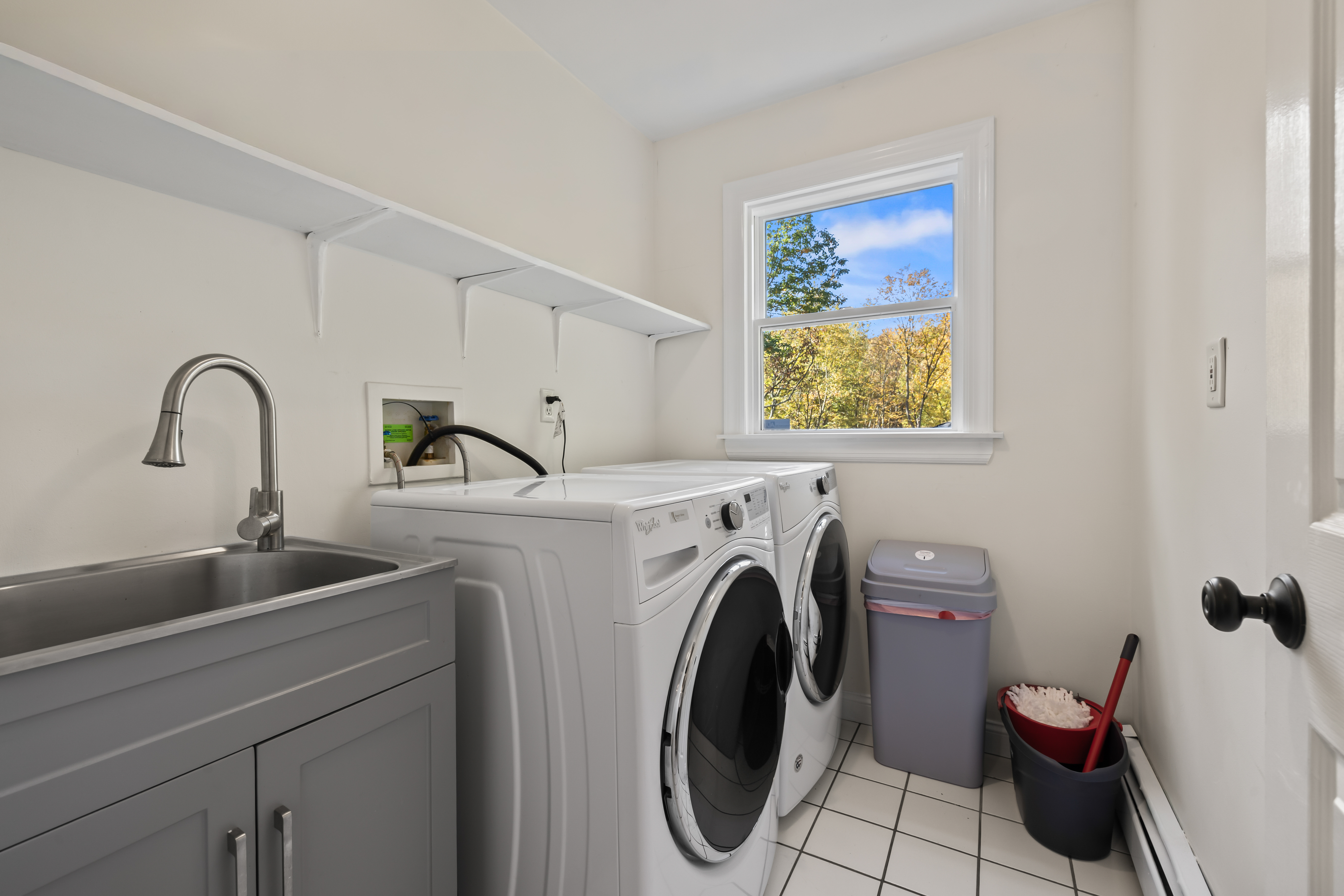 Bright laundry room with washer/dryer, utility sink, and natural light