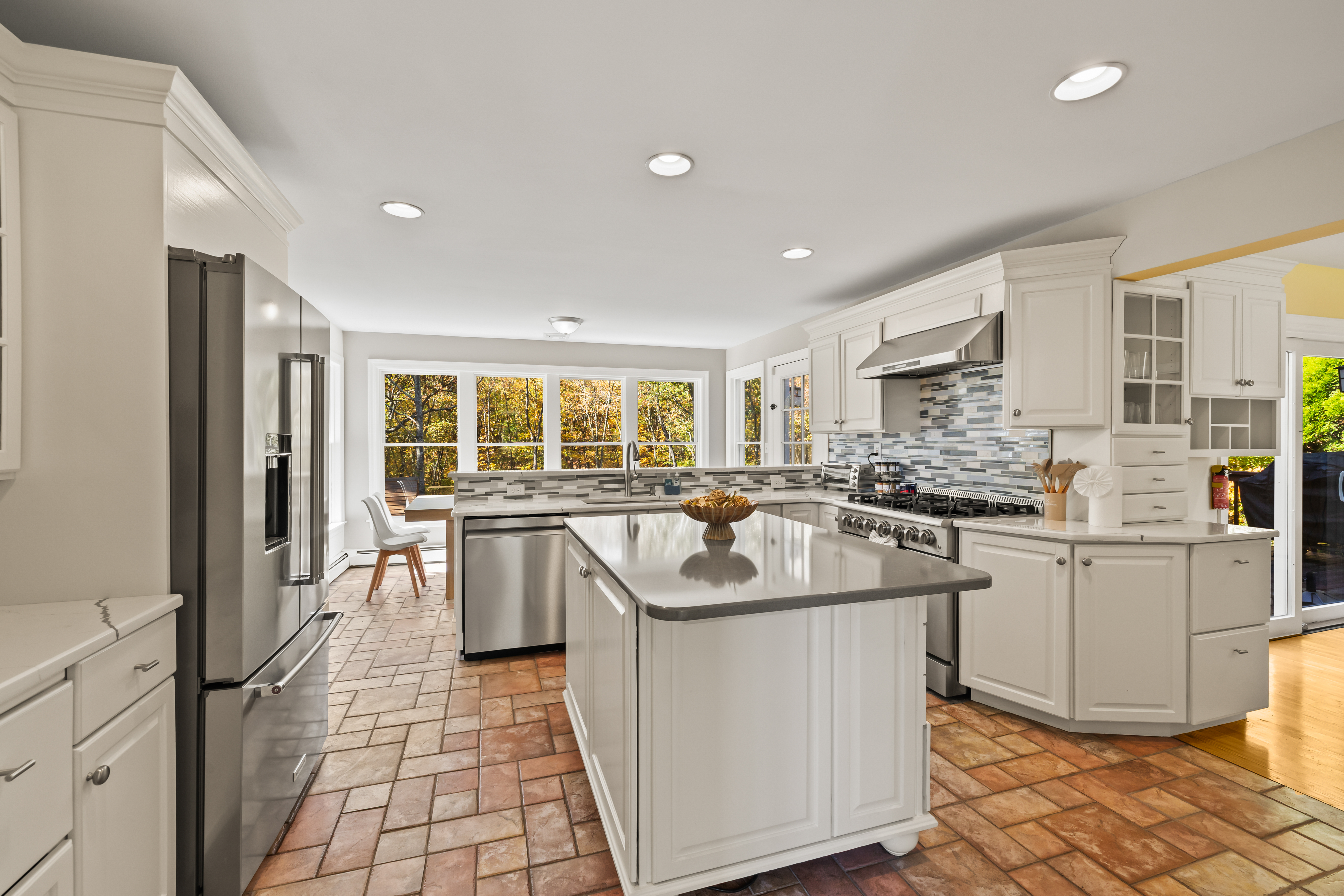 Bright gourmet kitchen with large island, stainless appliances, and sunny views