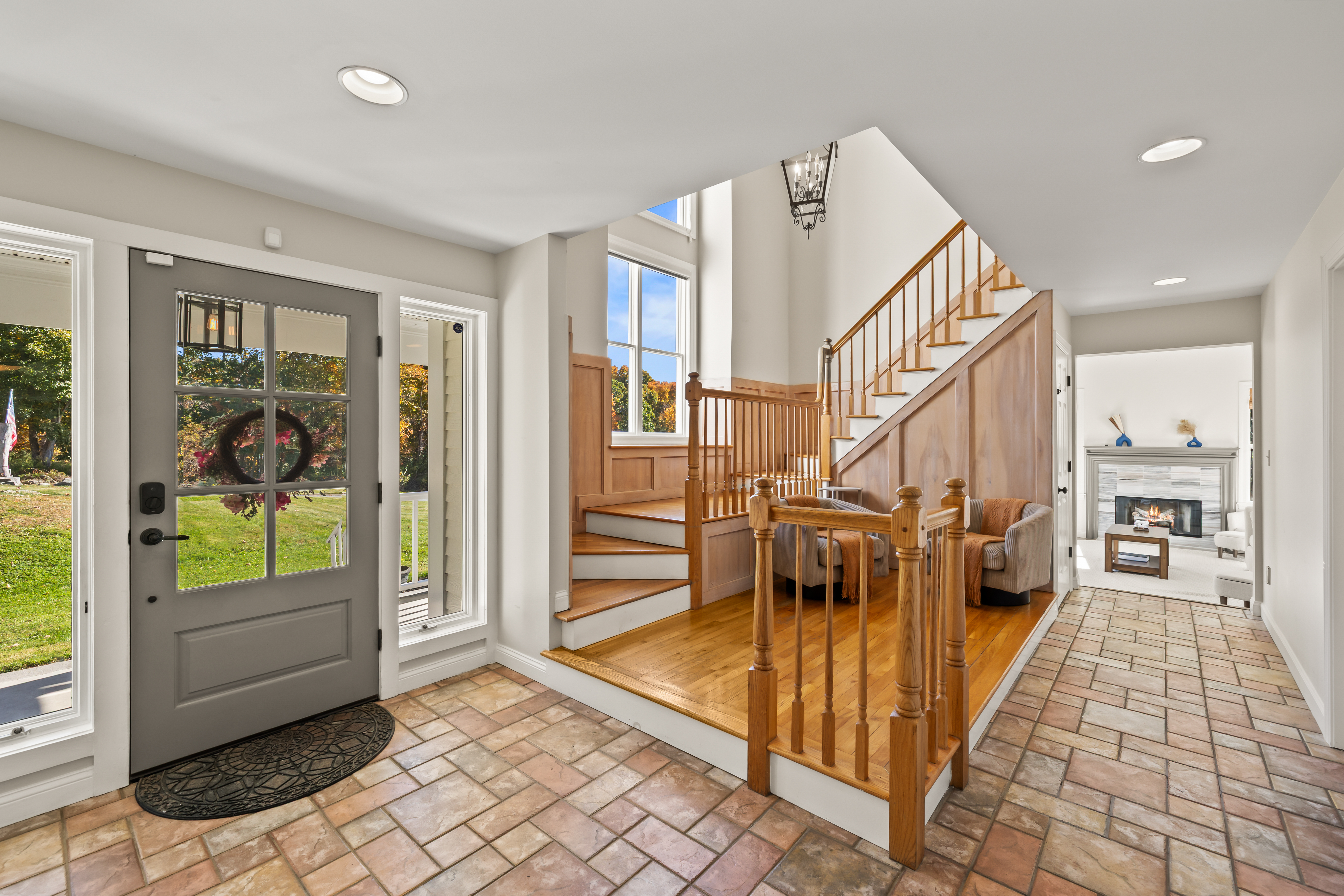 Bright, airy entryway with wood stairs and a welcoming open layout