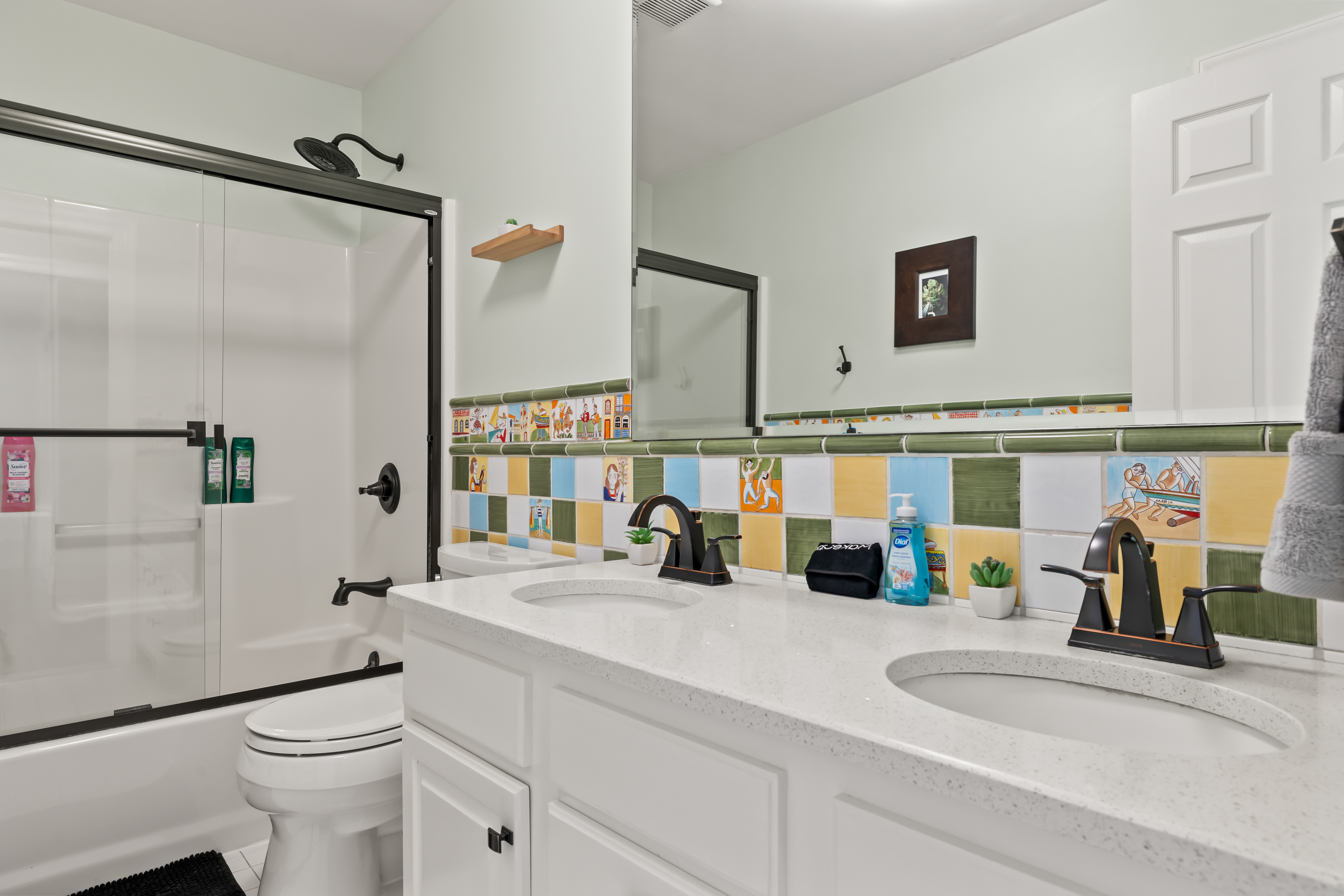 Bright double-vanity bathroom with colorful tile and modern finishes