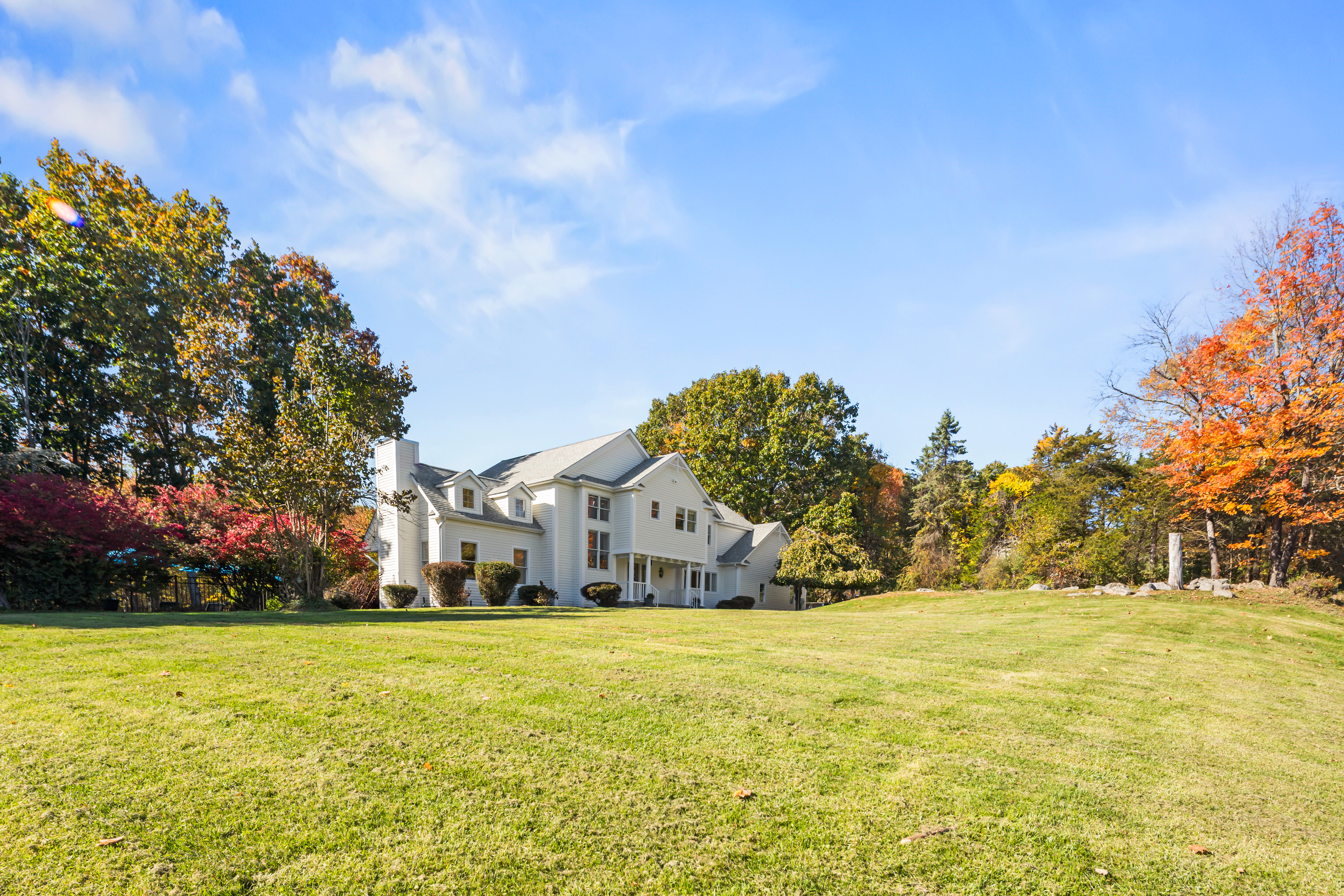Spacious lawn and peaceful wooded setting surround this charming home