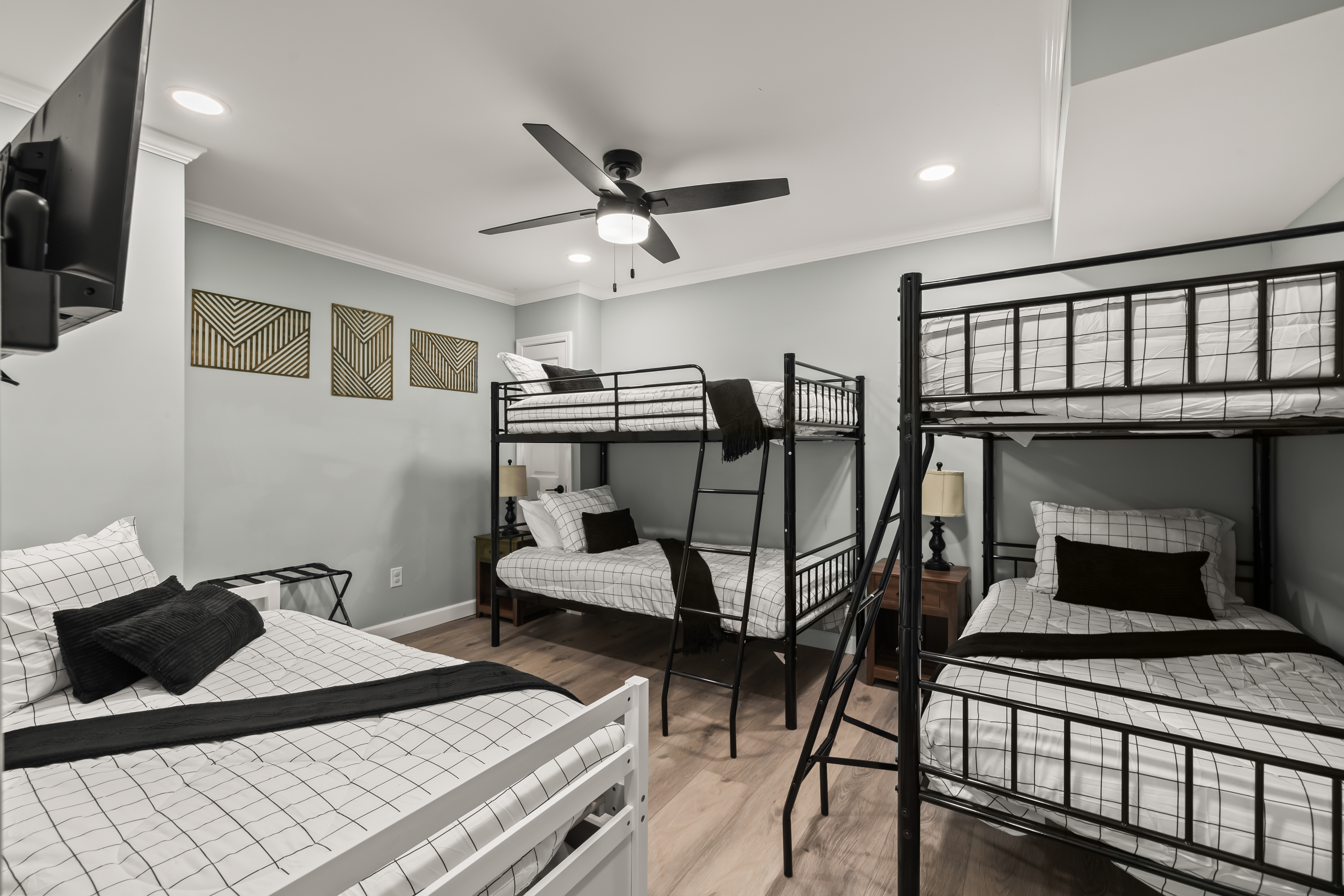 Spacious bunk room with TV, ceiling fan, and sleeping space for the whole crew