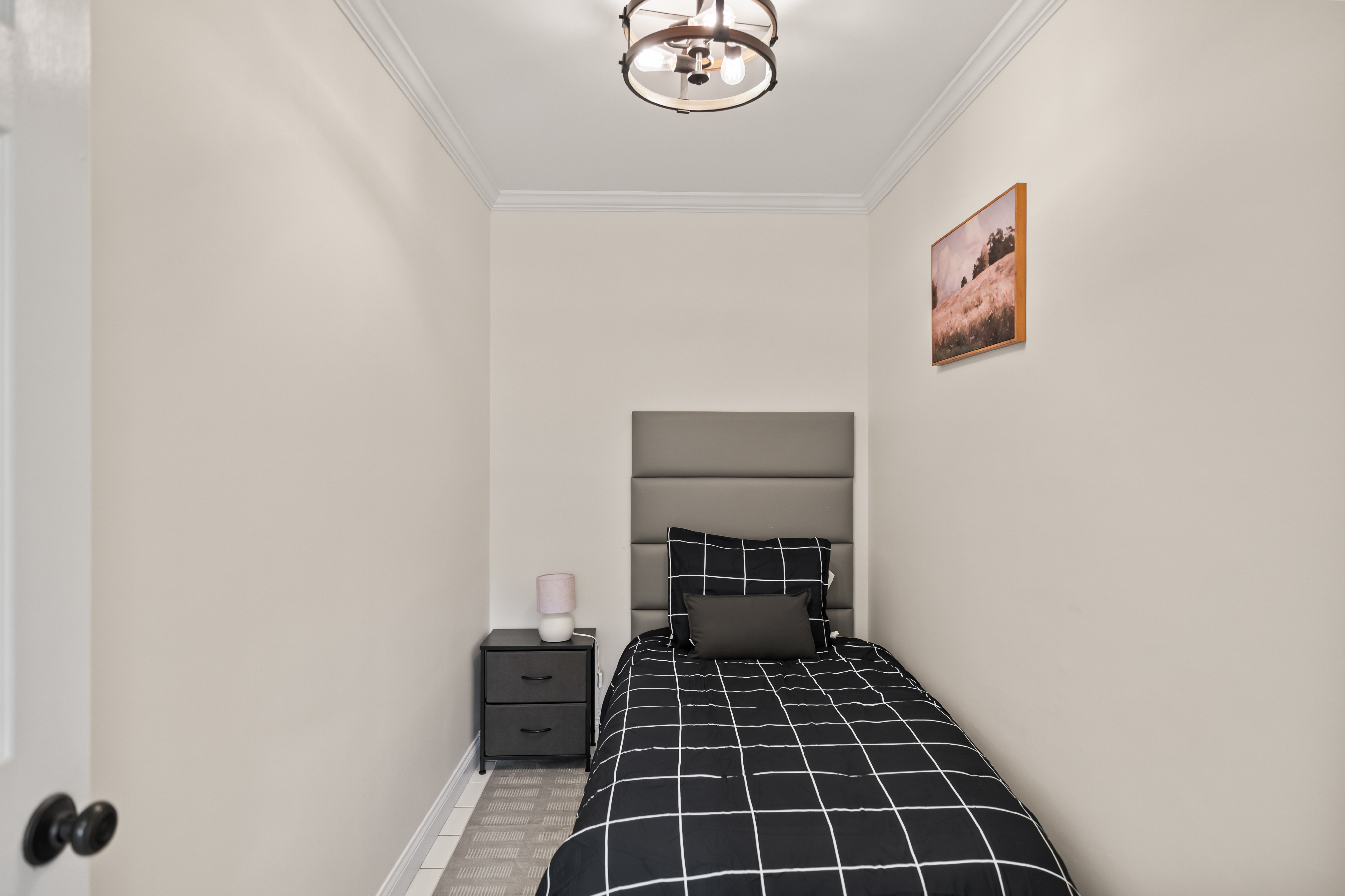Cozy modern single bedroom with sleek styling and bedside table