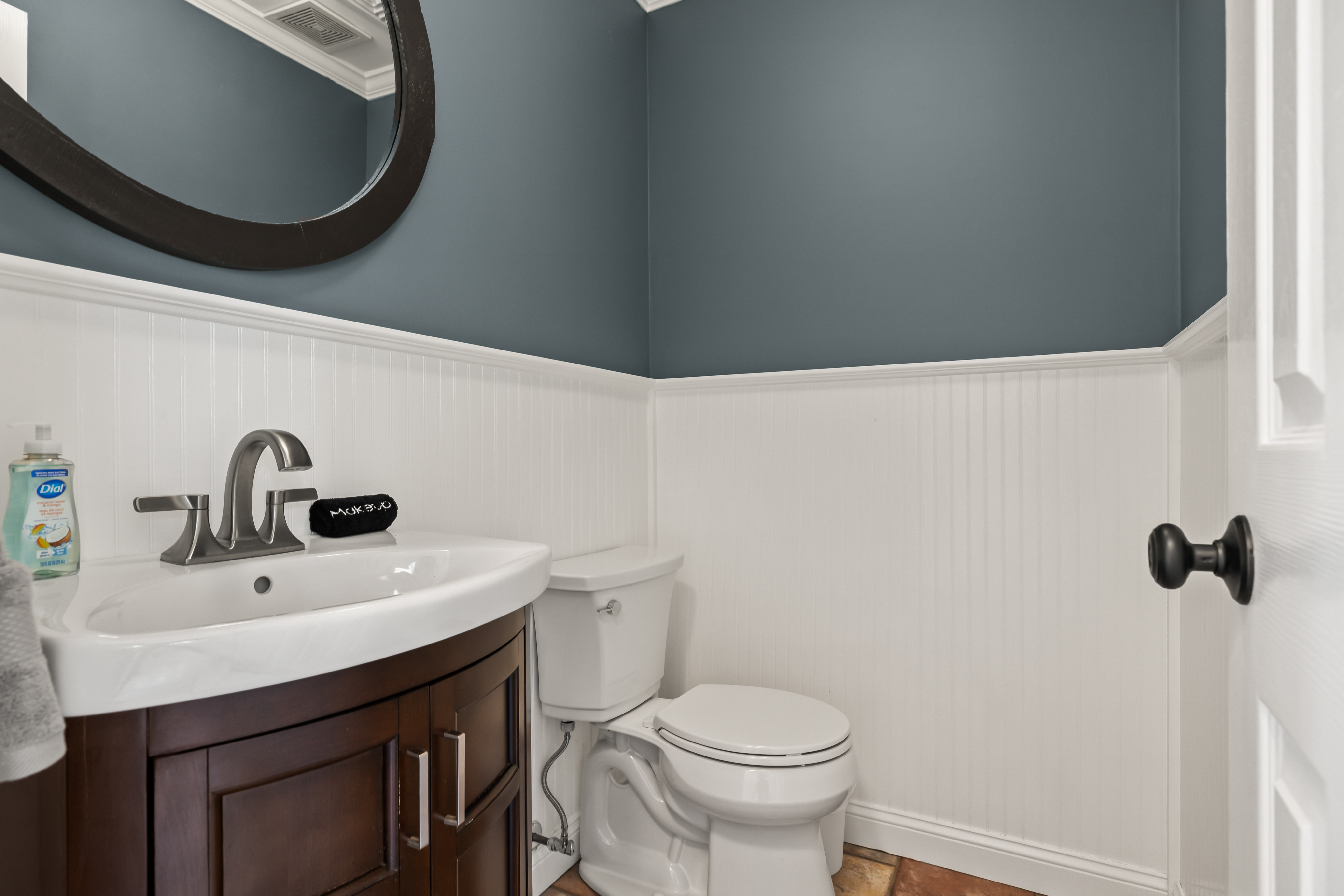 Stylish half bath with modern vanity, crisp beadboard, and elegant finishes