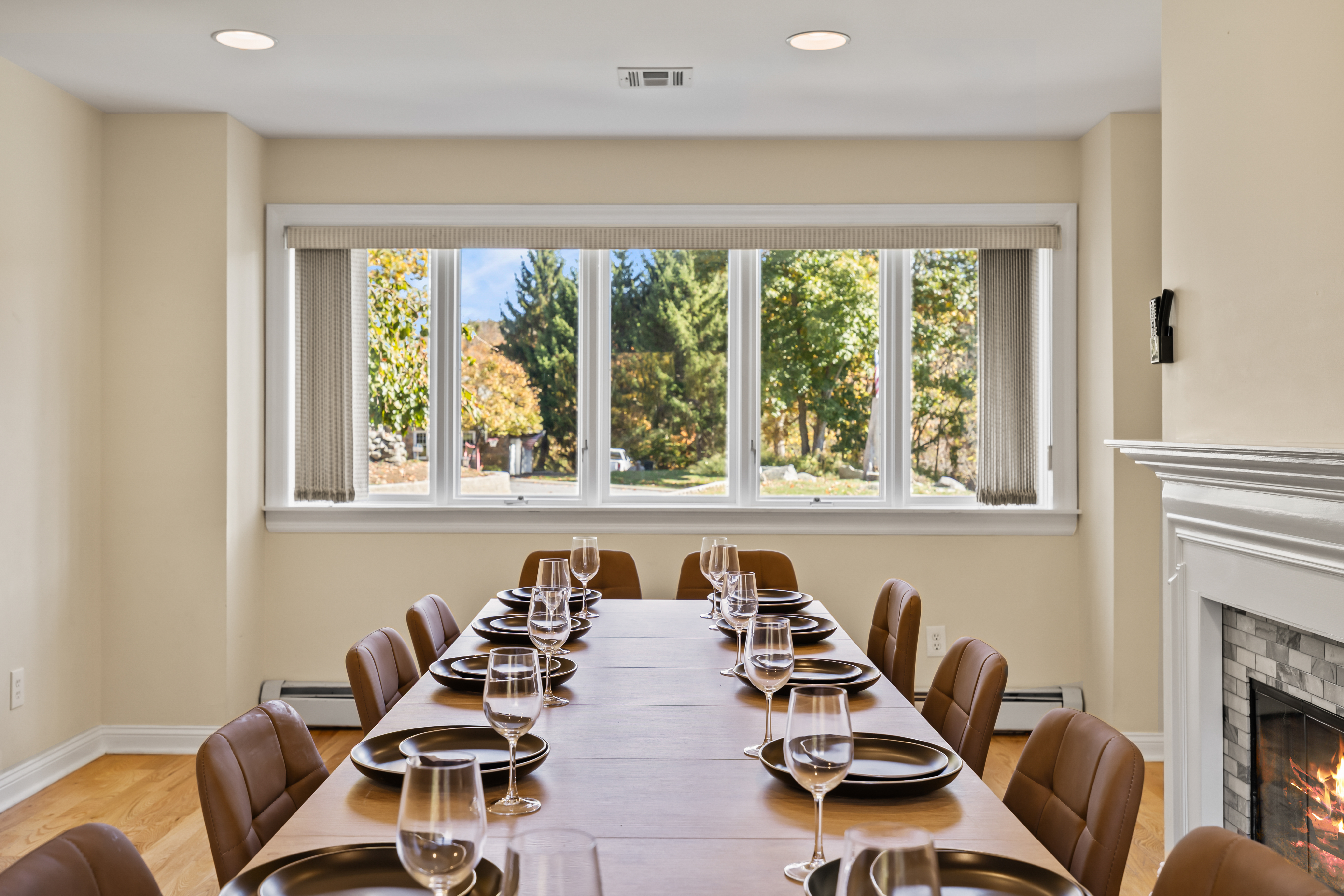 Bright dining room with large picture window and cozy fireplace
