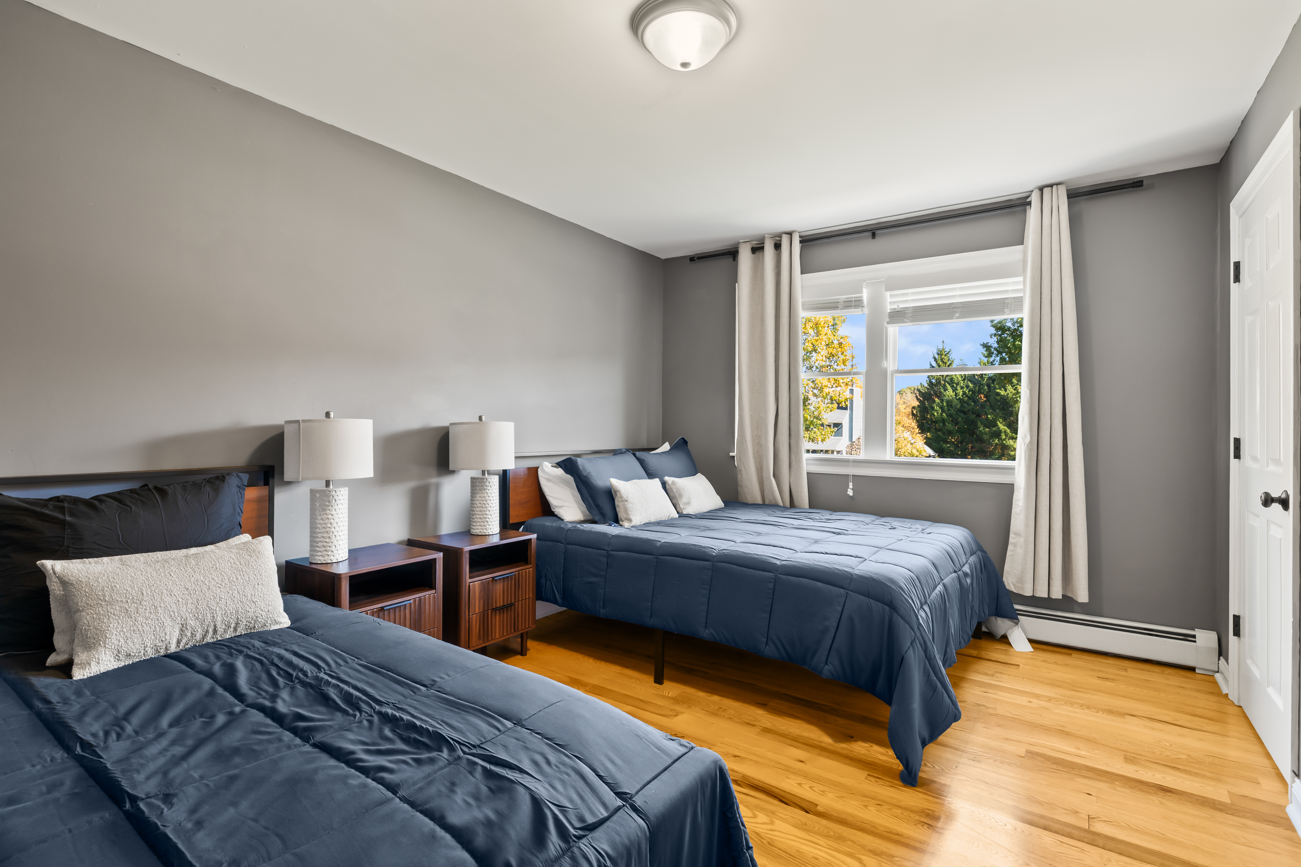Bright double bedroom with two cozy beds and sunny window views