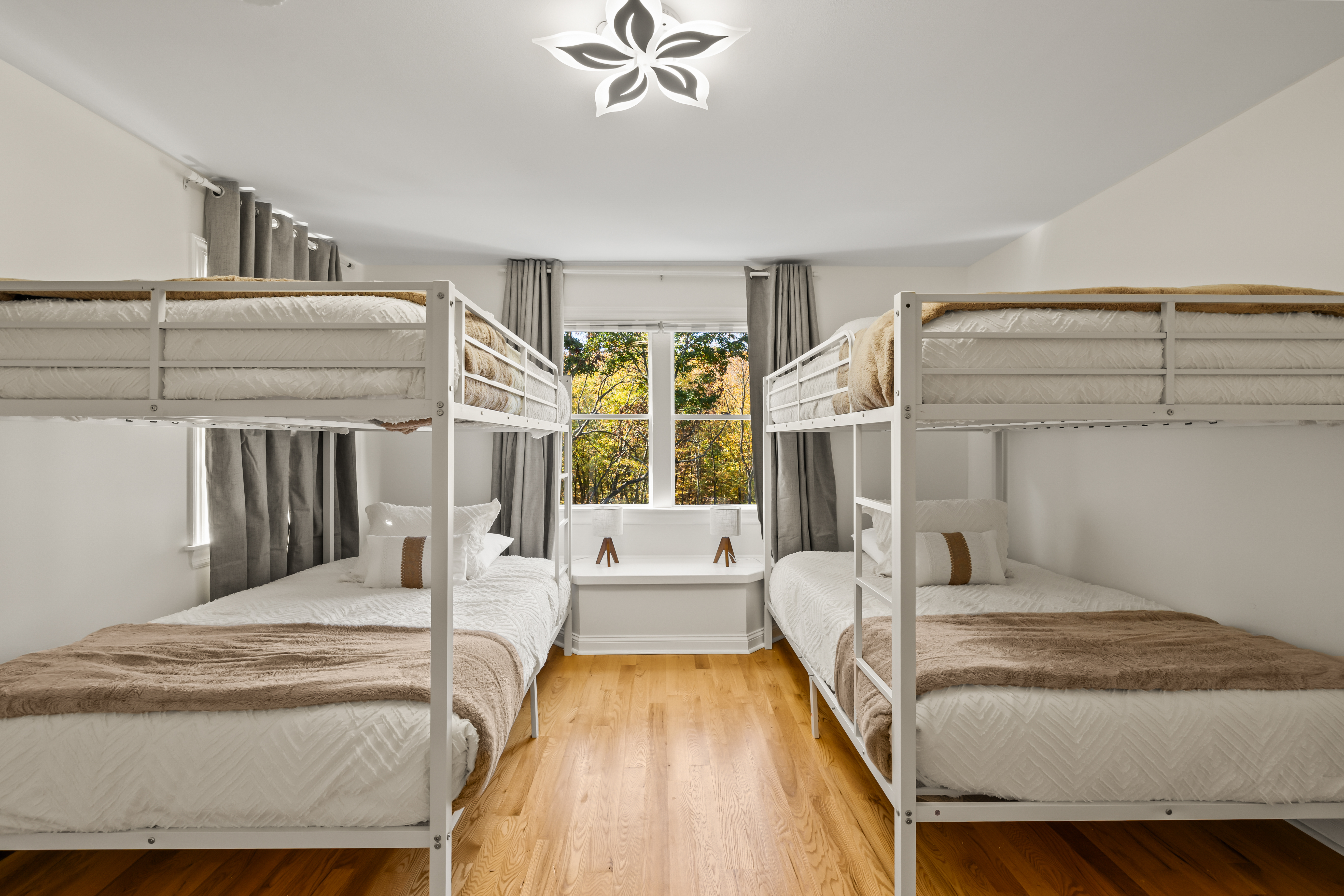 Bright bunk room for 4 with leafy views and cozy, modern touches