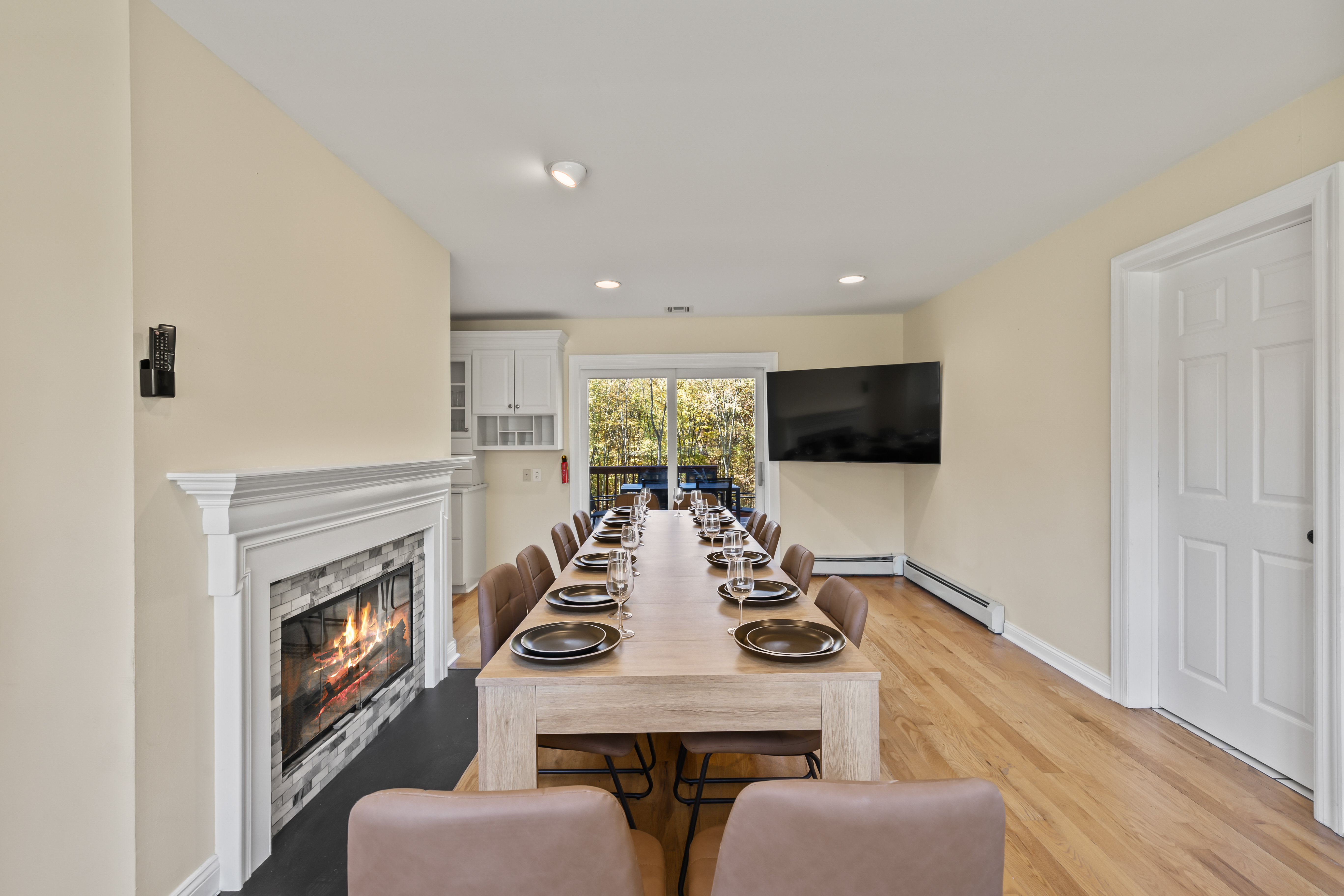 Spacious dining room with fireplace, TV, and deck access for group gatherings