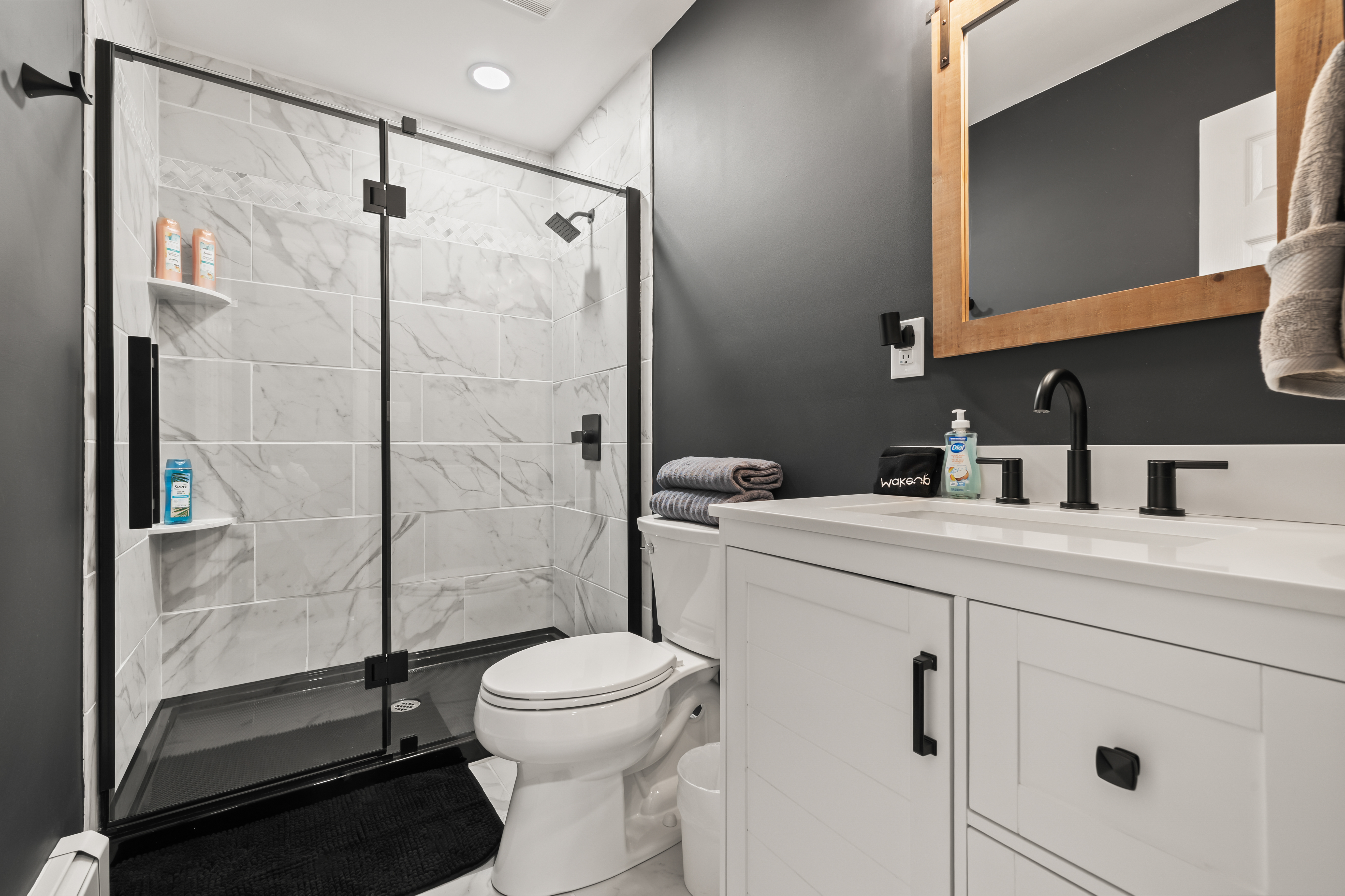 Modern spa-style bathroom with glass shower and sleek black finishes
