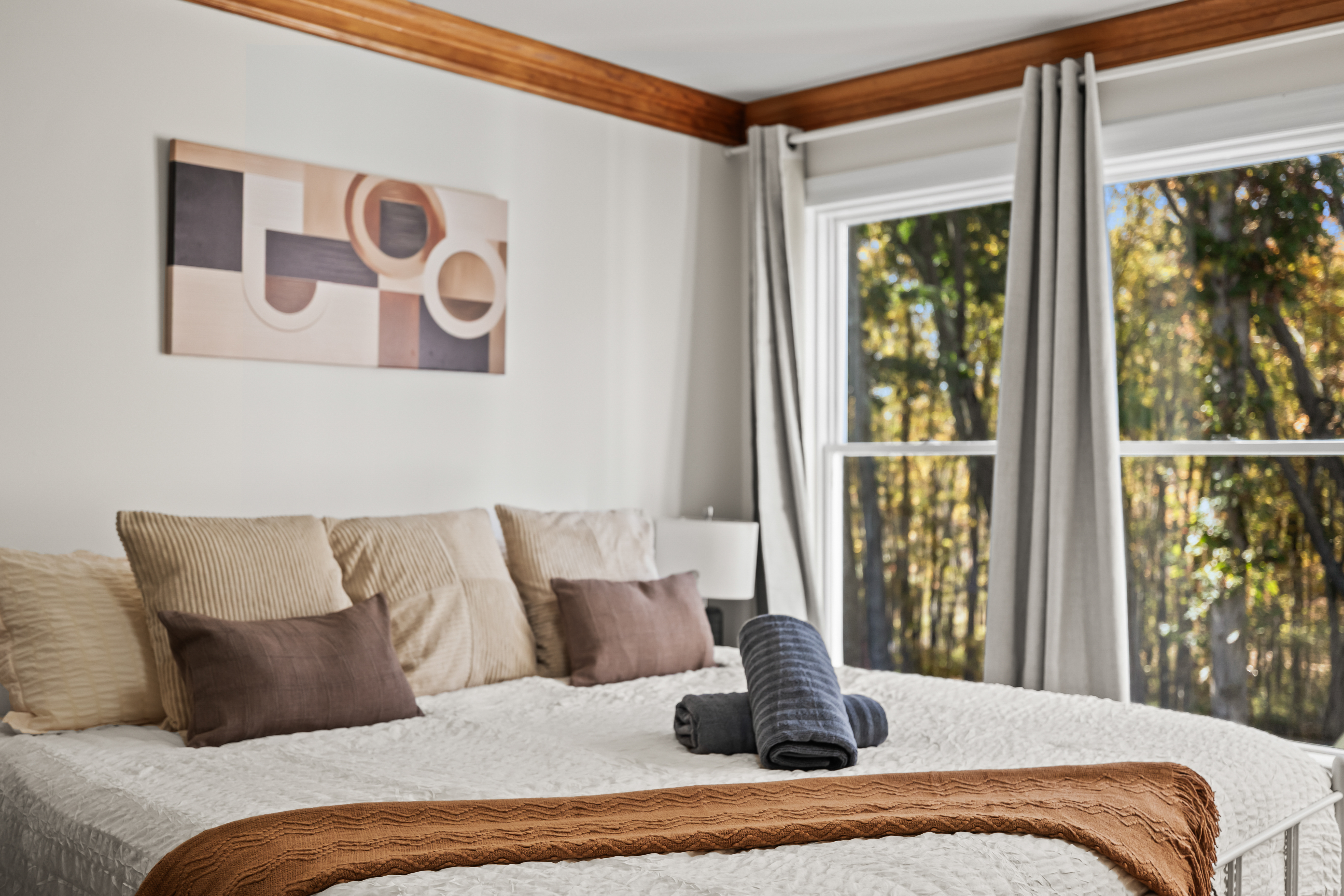 Bright, cozy bedroom with wooded views and warm modern touches