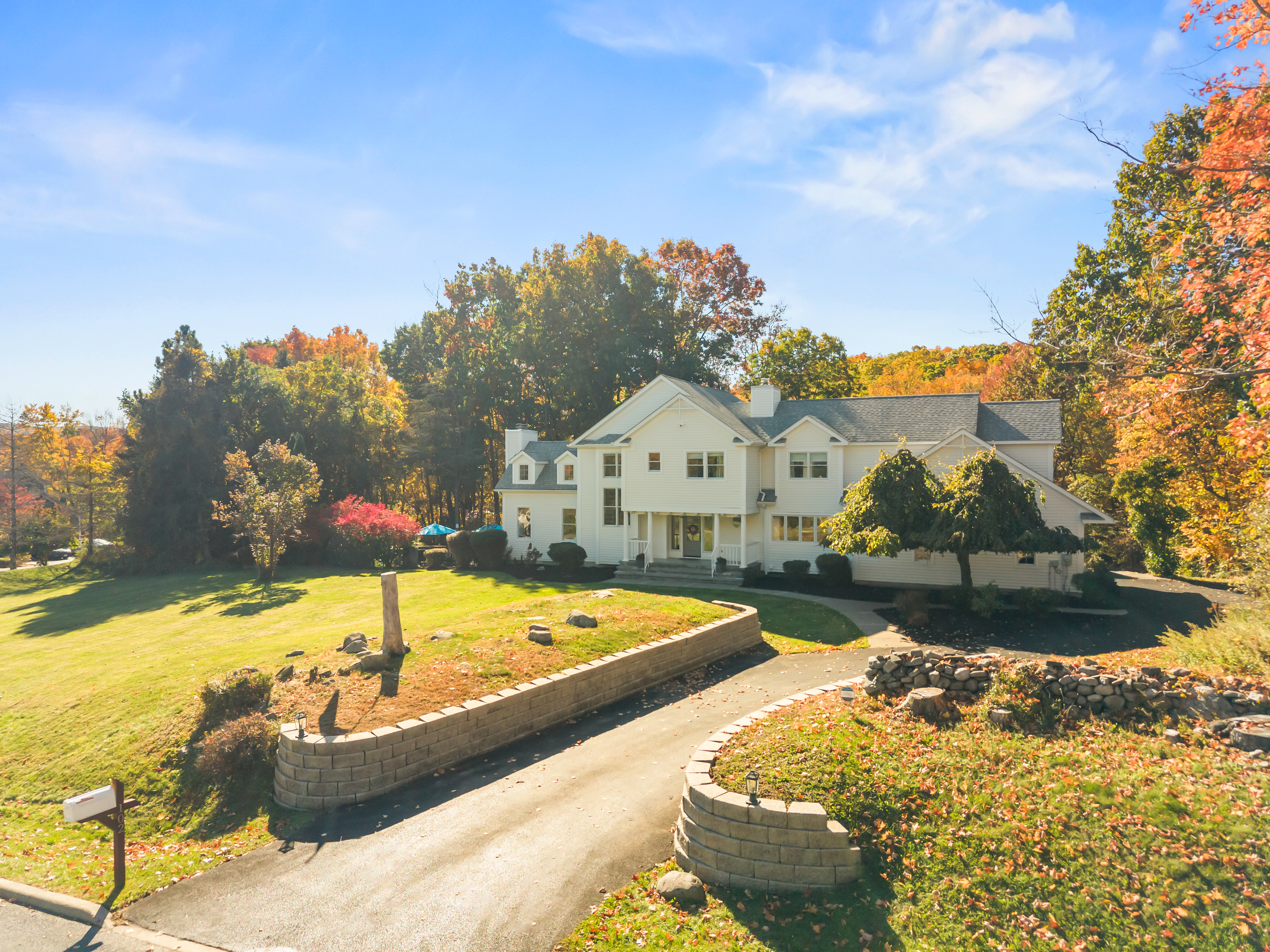 Elegant country home with sweeping lawn and beautiful fall scenery