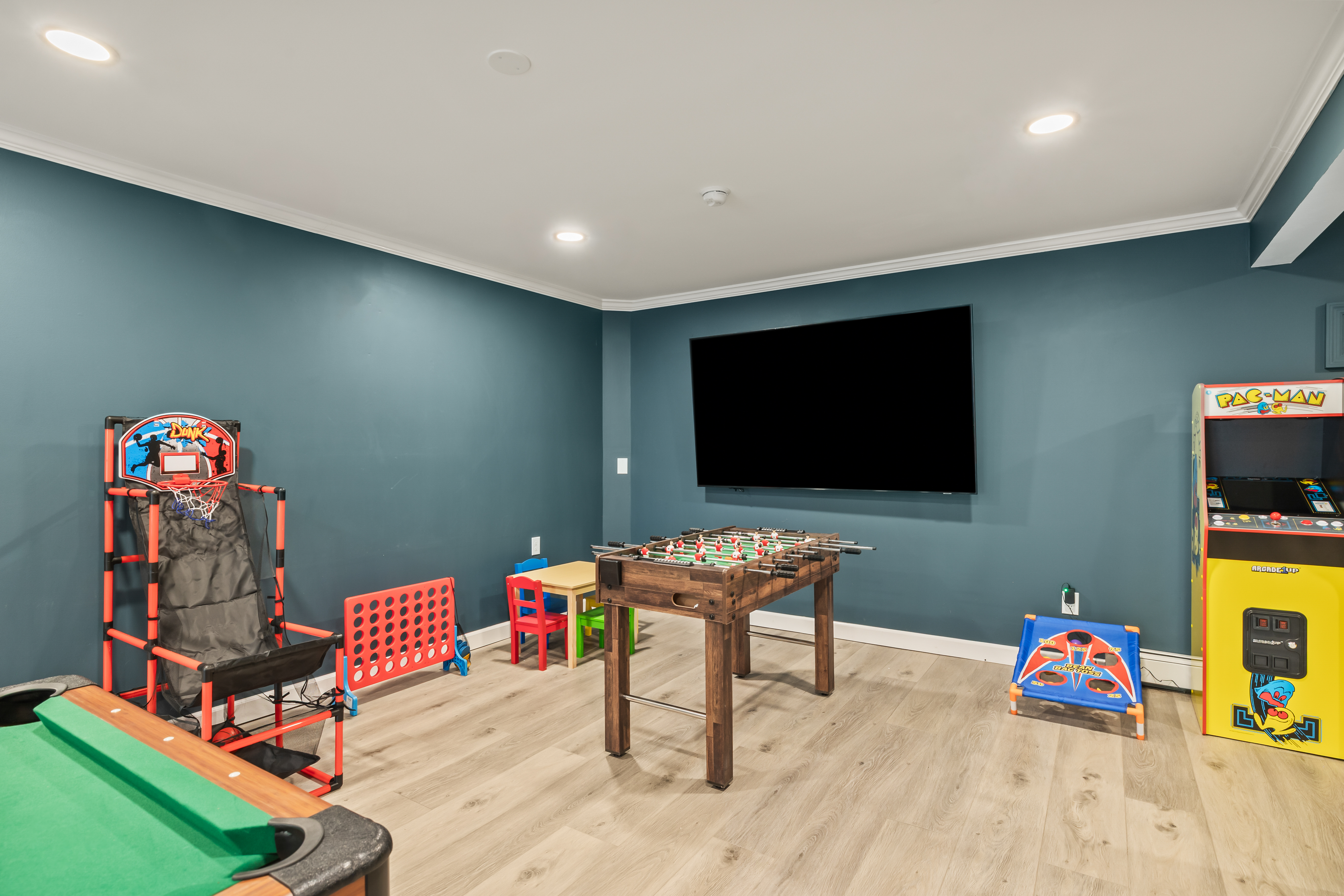 Fun-filled game room with arcade, foosball, TV, and family-friendly play space