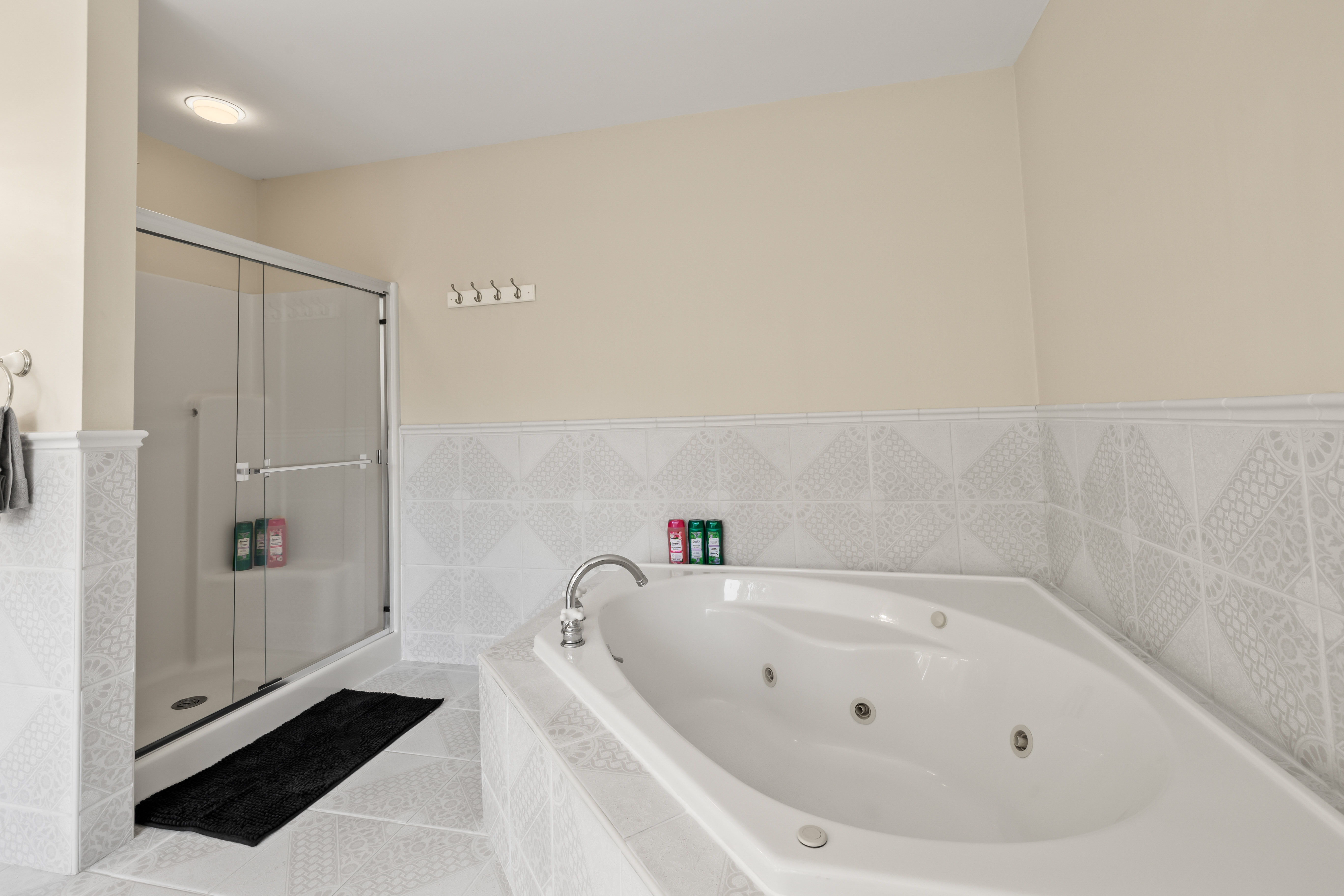 Spa-like bathroom with jetted soaking tub and separate glass shower