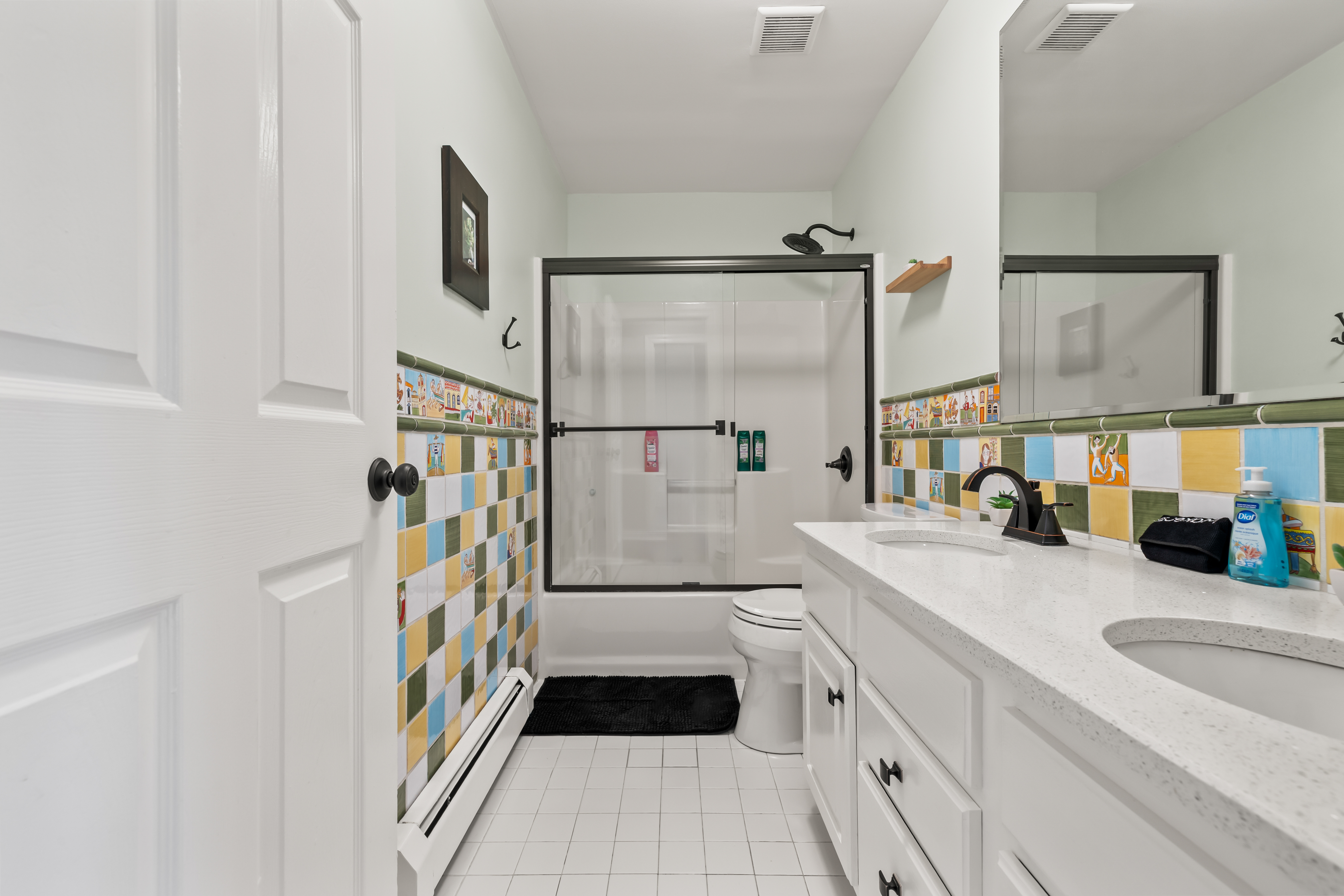 Bright full bath with double vanity and colorful tile accents