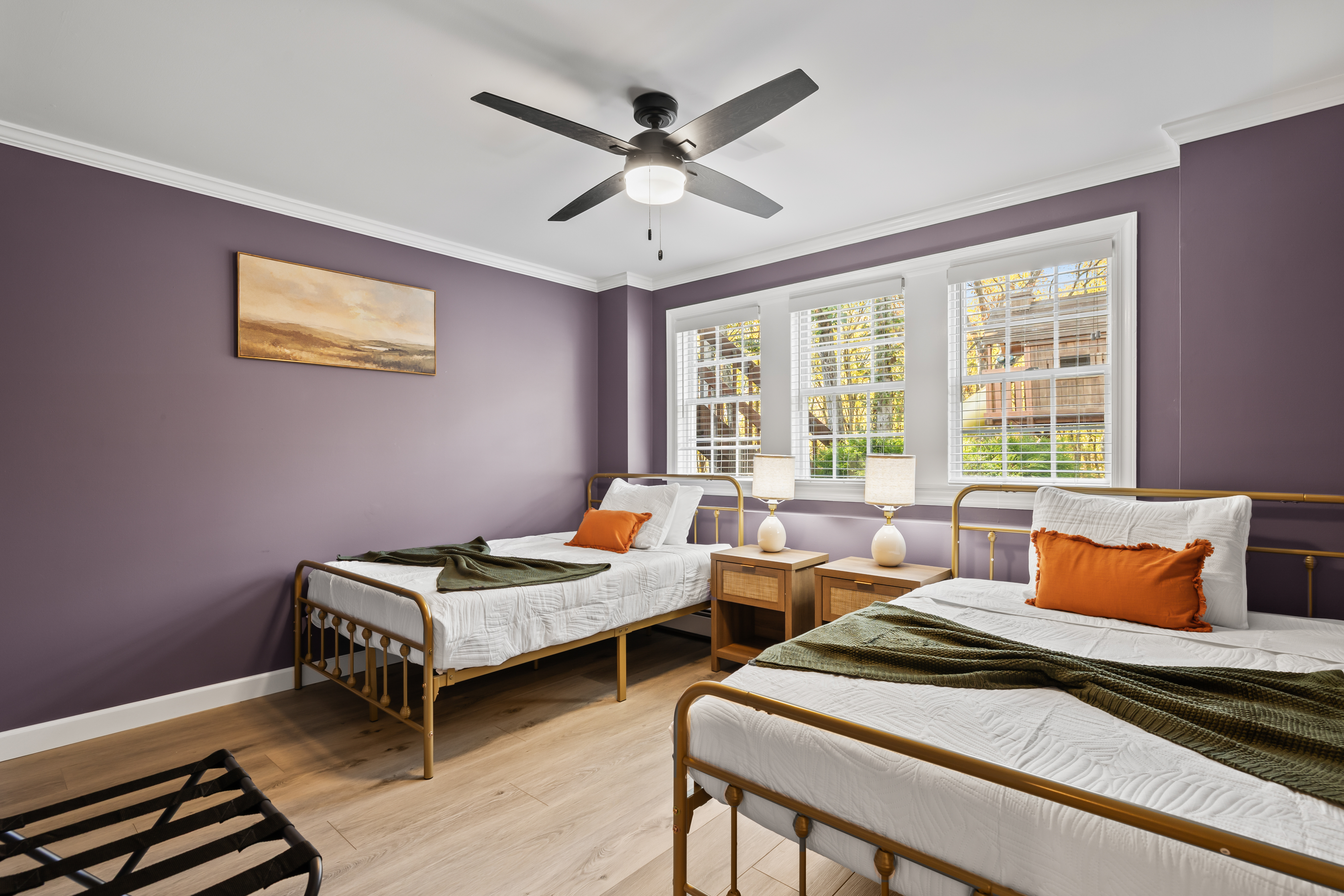 Bright double bedroom with stylish decor, big windows, and cozy guest setup