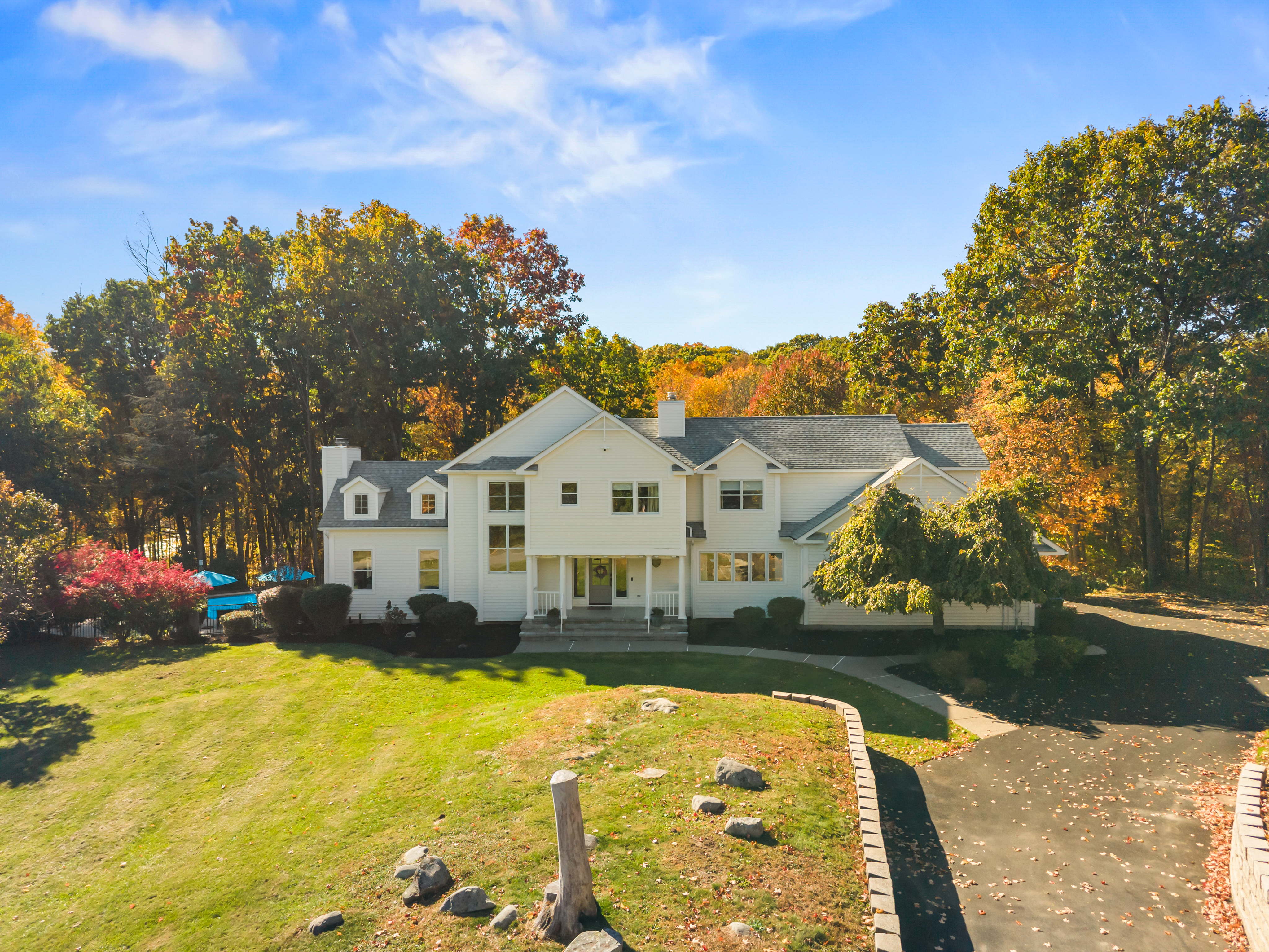 Elegant estate with sprawling lawn, private drive, and stunning fall views