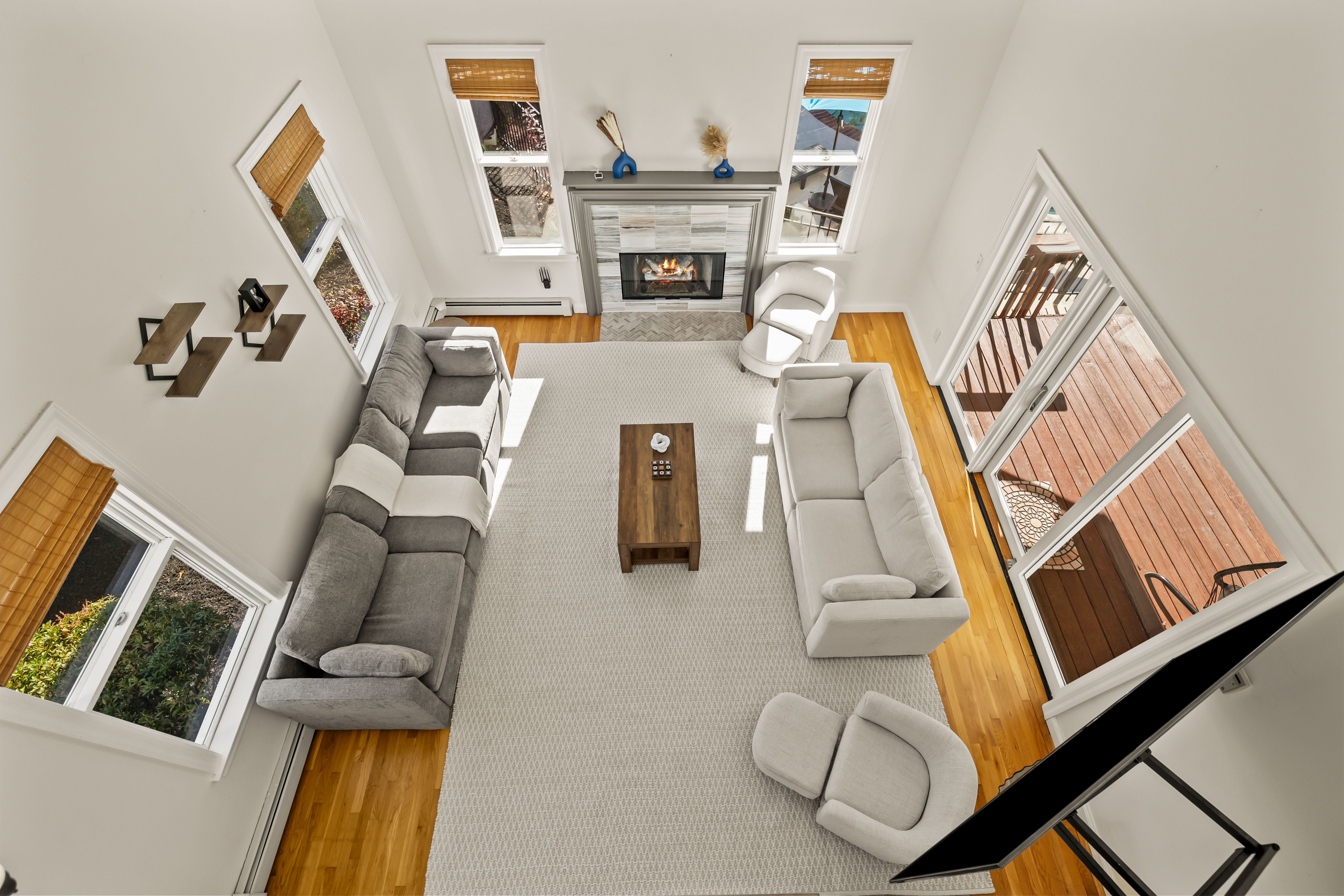 Bright vaulted living room with fireplace and deck access