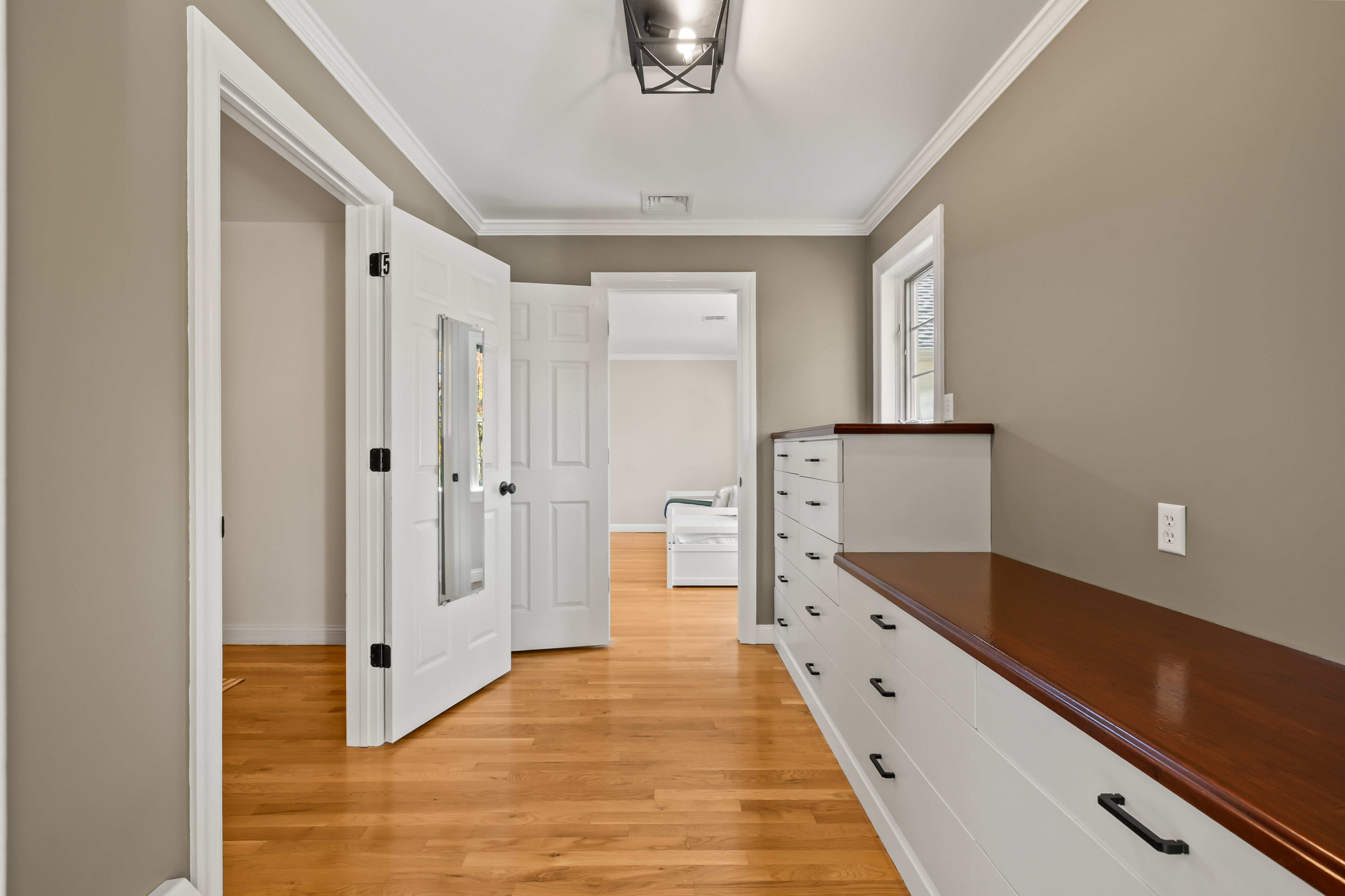 Bright hallway with hardwood floors and built-in storage