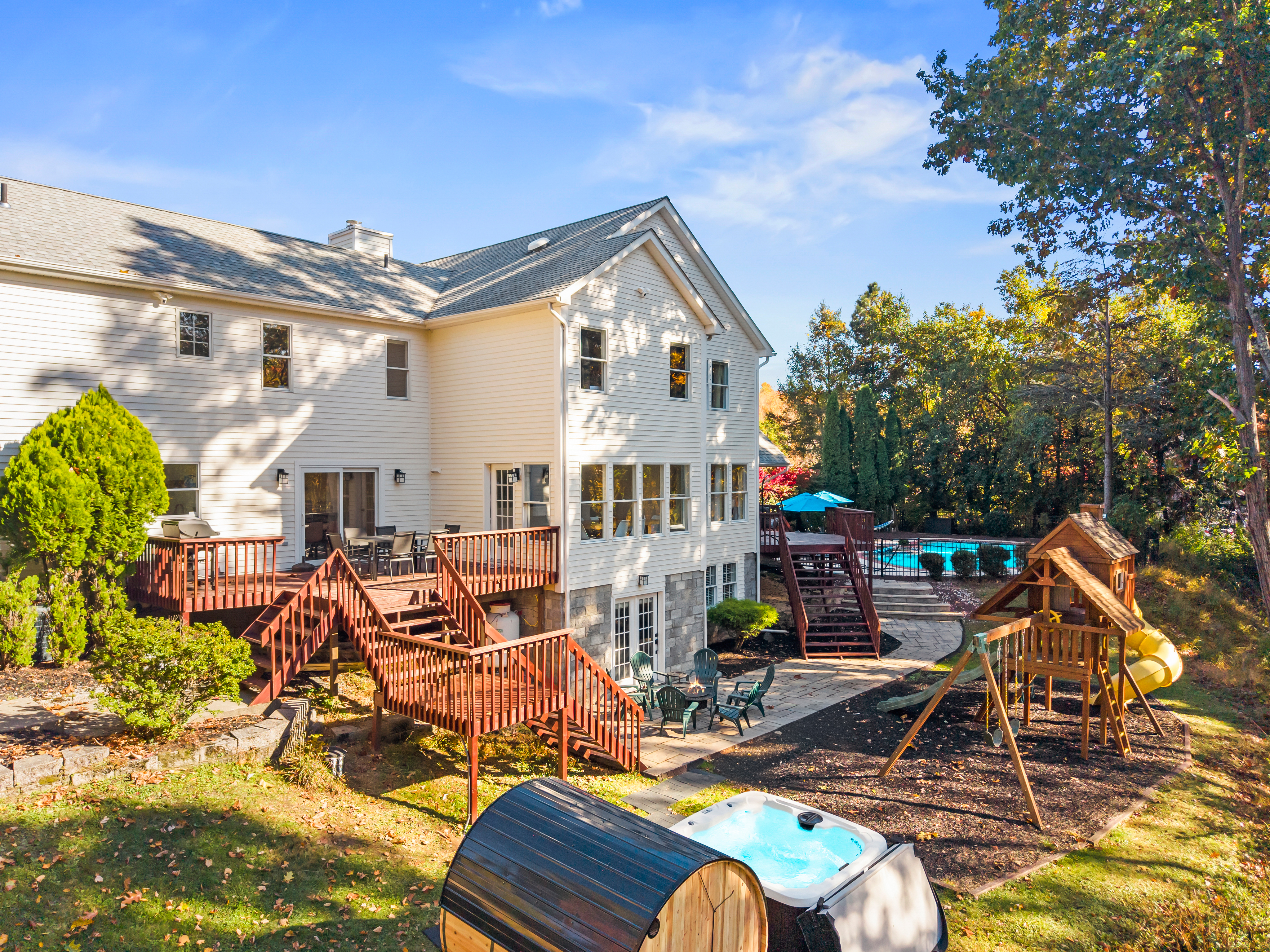 Expansive backyard with hot tub, pool, decks & family-friendly play area