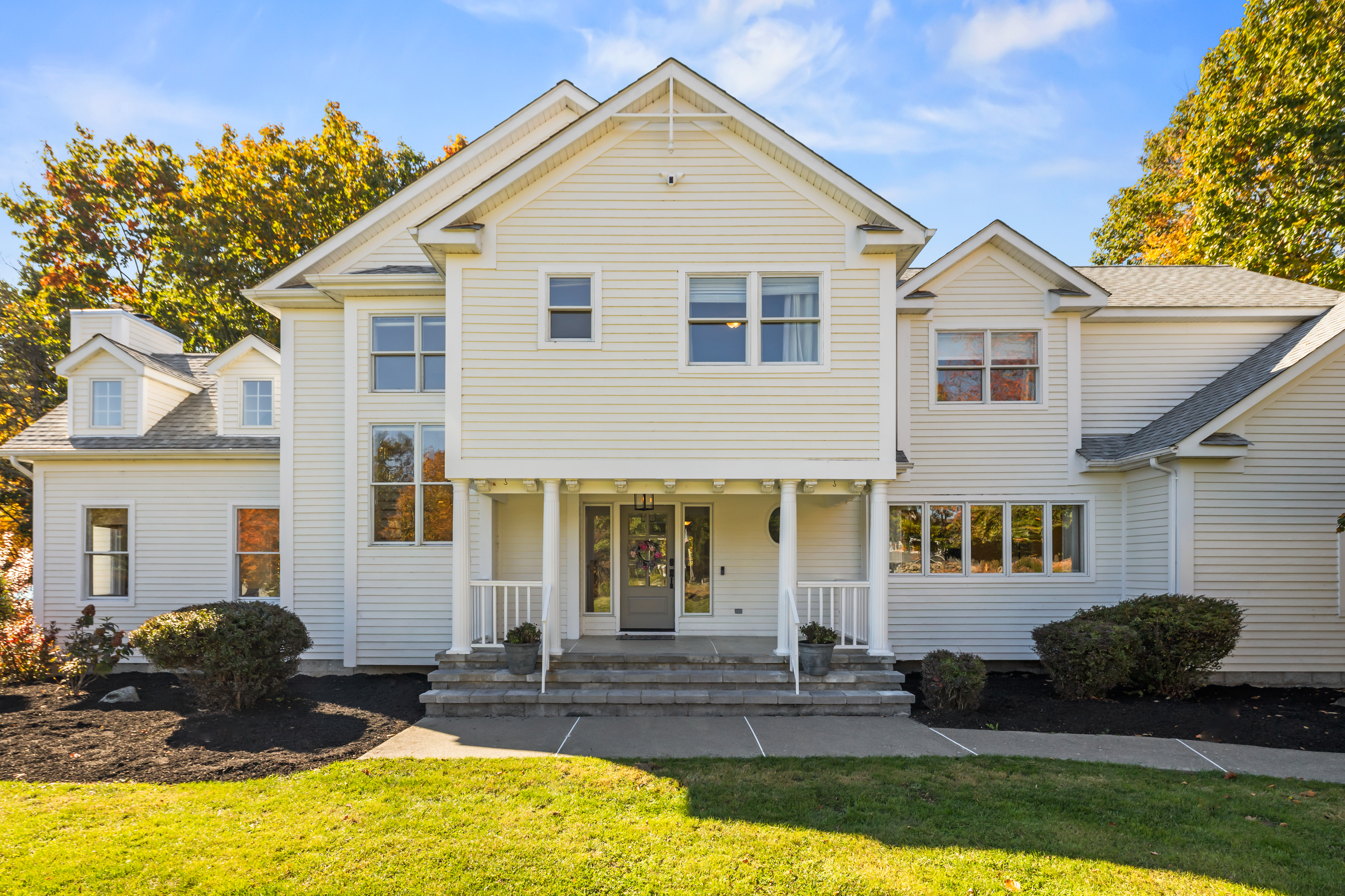 Spacious home with inviting porch, big windows, and beautiful curb appeal