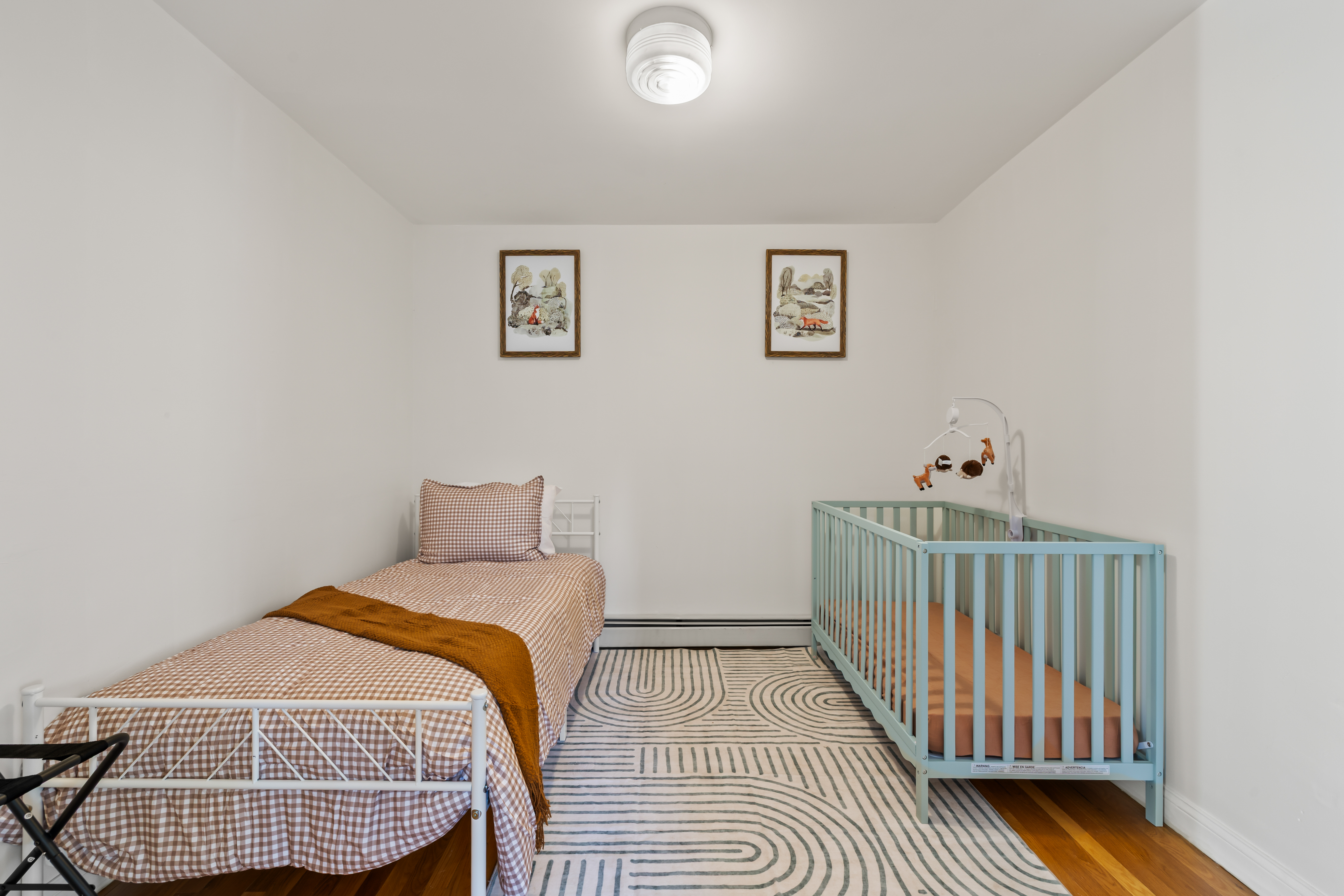 Family-friendly kids’ room with twin bed, crib, and bright minimalist style