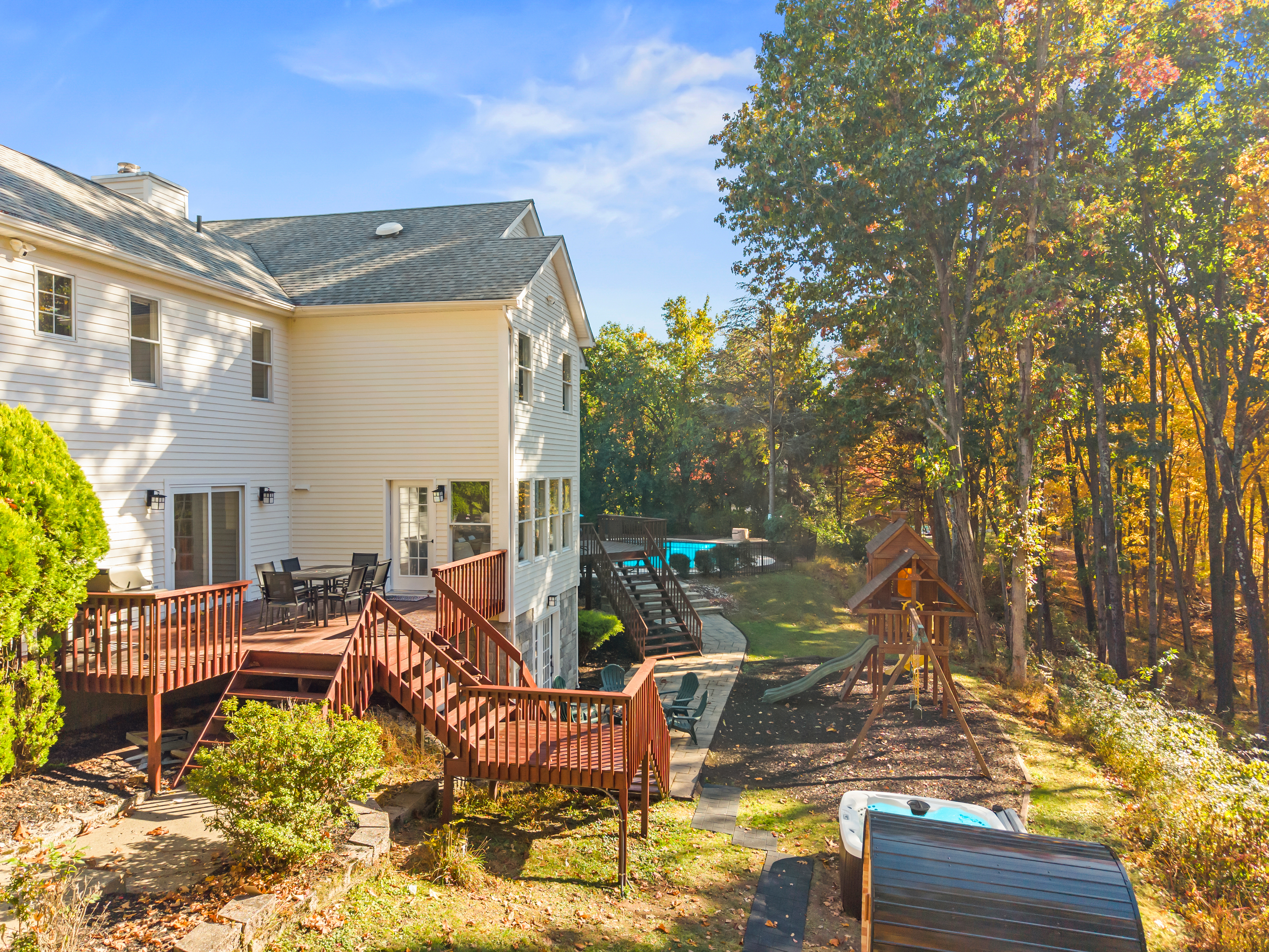 Private wooded backyard with deck, pool, and family-friendly playset